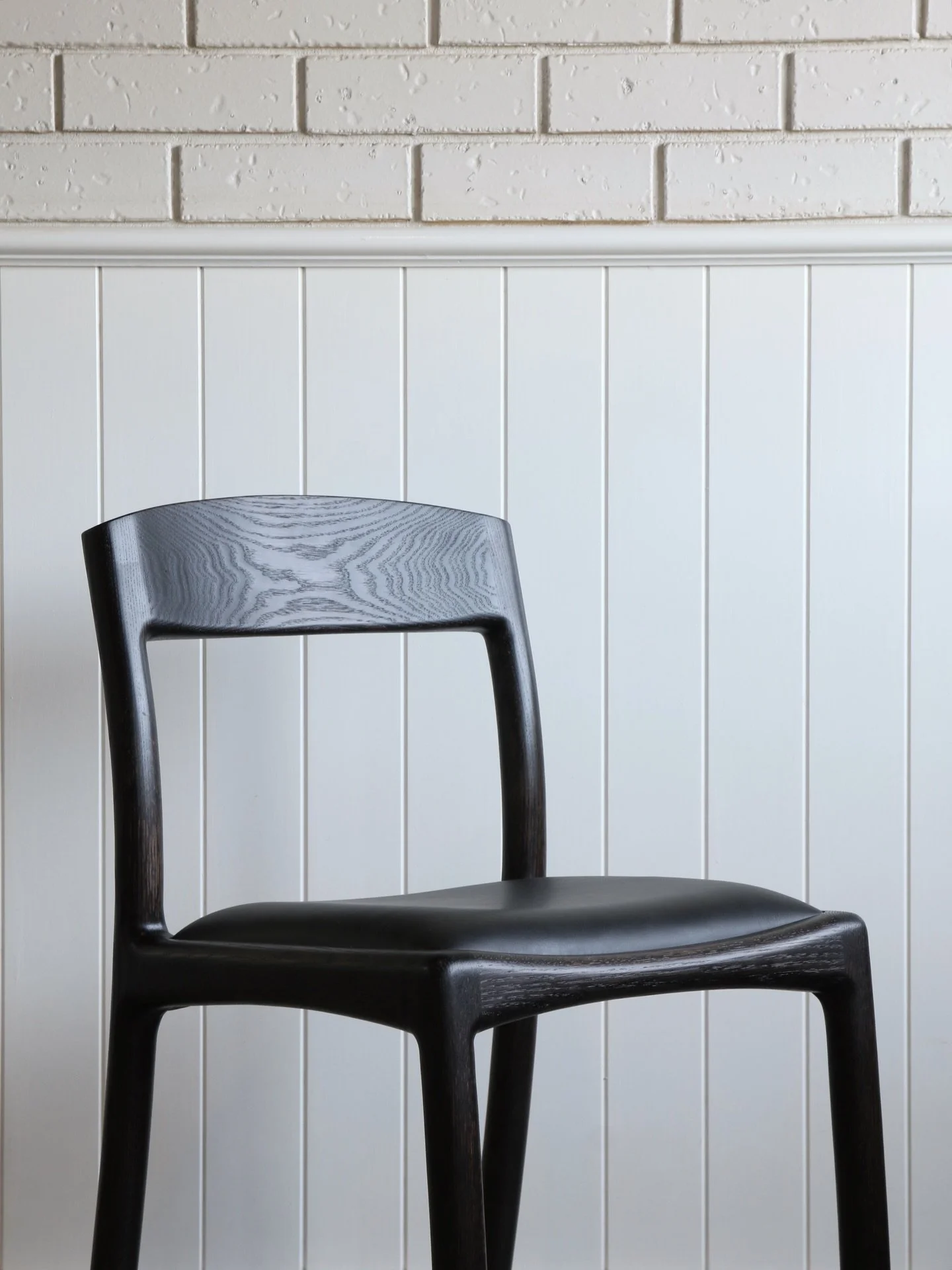 Curved Dining Chair &ndash; Black Stain &amp; Leather

The black leather and stain combination really emphasise the shape and contours of this chair. The curved nature of the design is intended to invite comfort and create something you would want to
