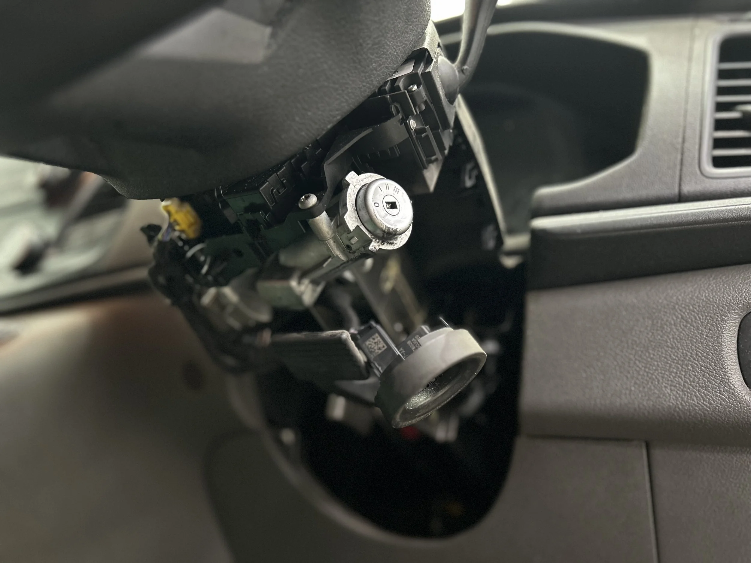 Close-up of a car dashboard with exposed internal components and a visible ignition lock mechanism.