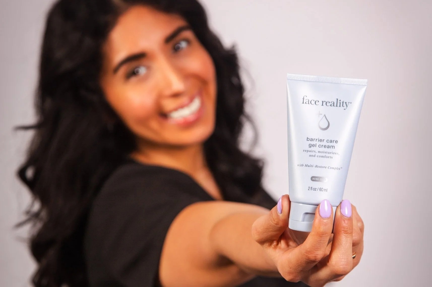 An image of a woman holding a "face reality" barrier care gel cream.