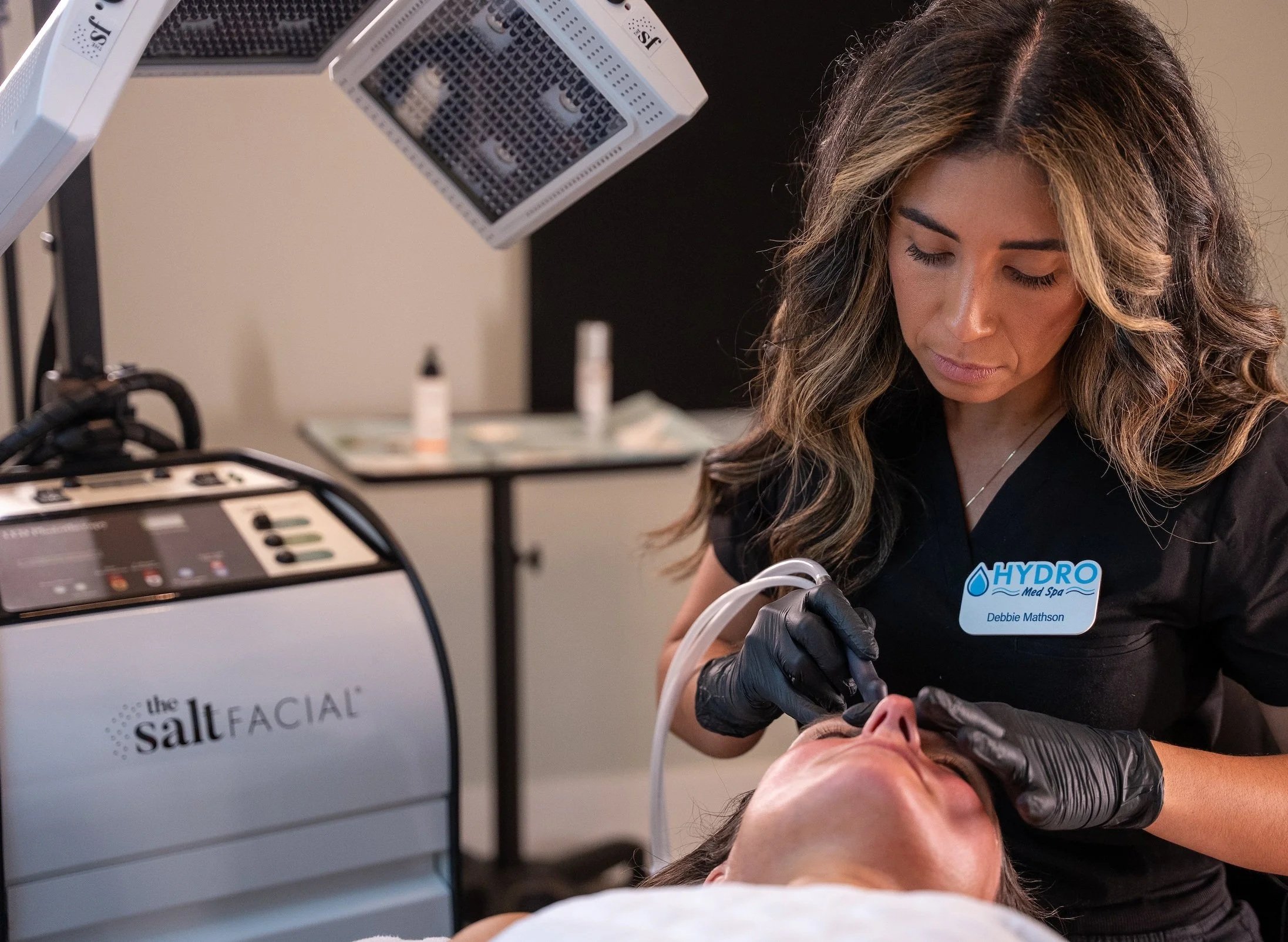 An image of a woman giving someone a salt facial.
