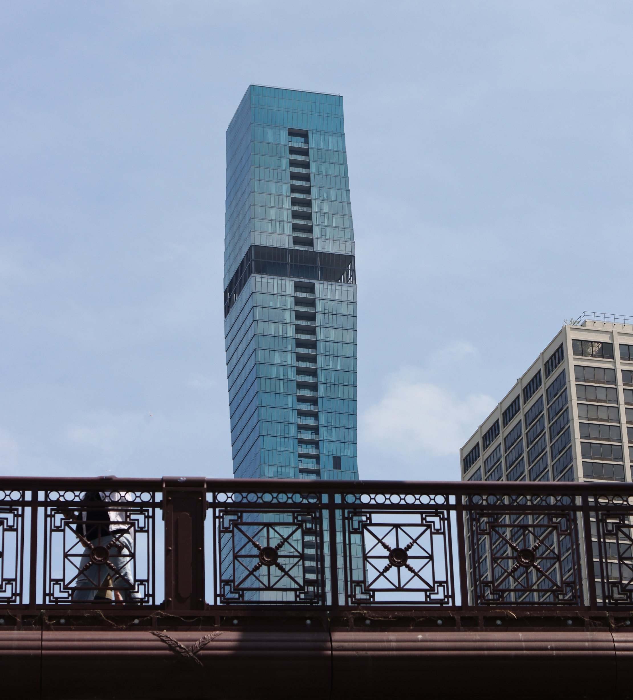 The dark stripes are open spaces to allow wind to breeze through without deflecting the whole building.