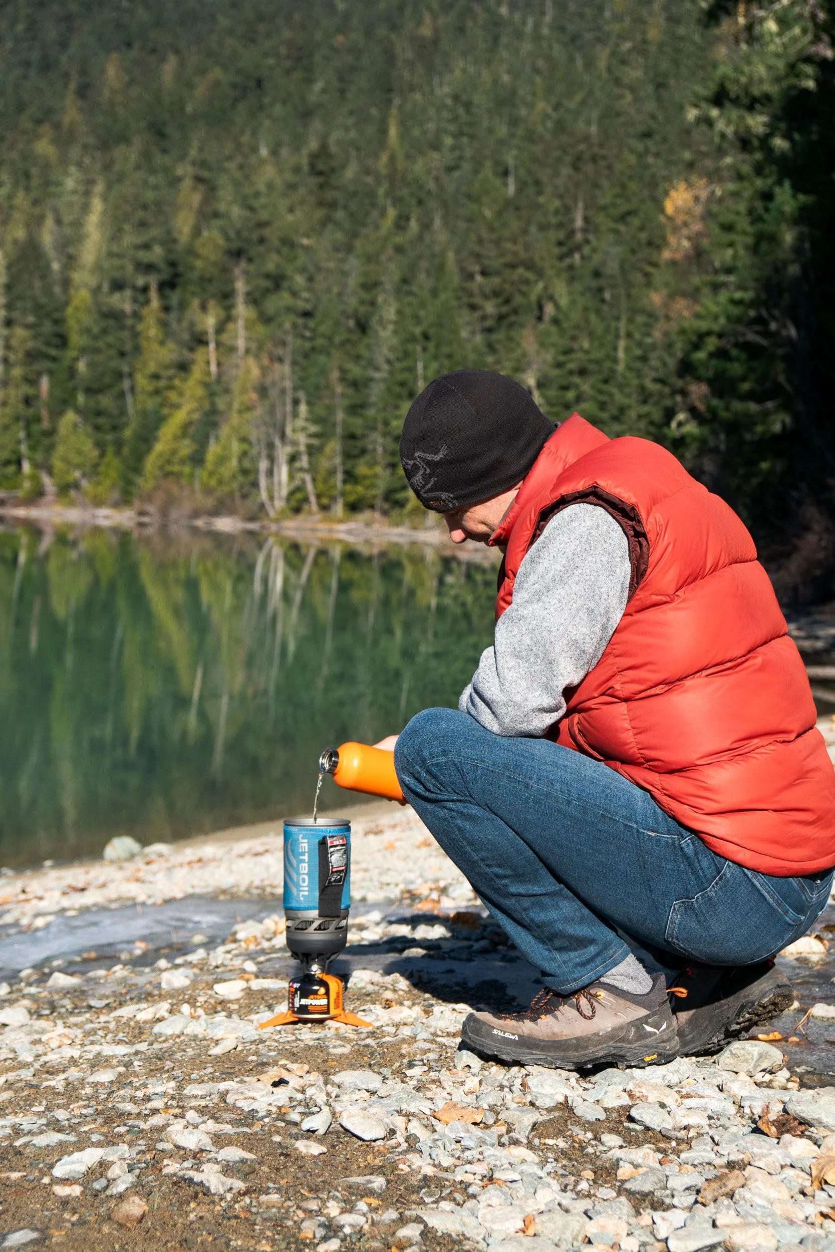  Pouring water in a Jetboil all-in-one system stove in front of Cheakamus lake in British Columbia 