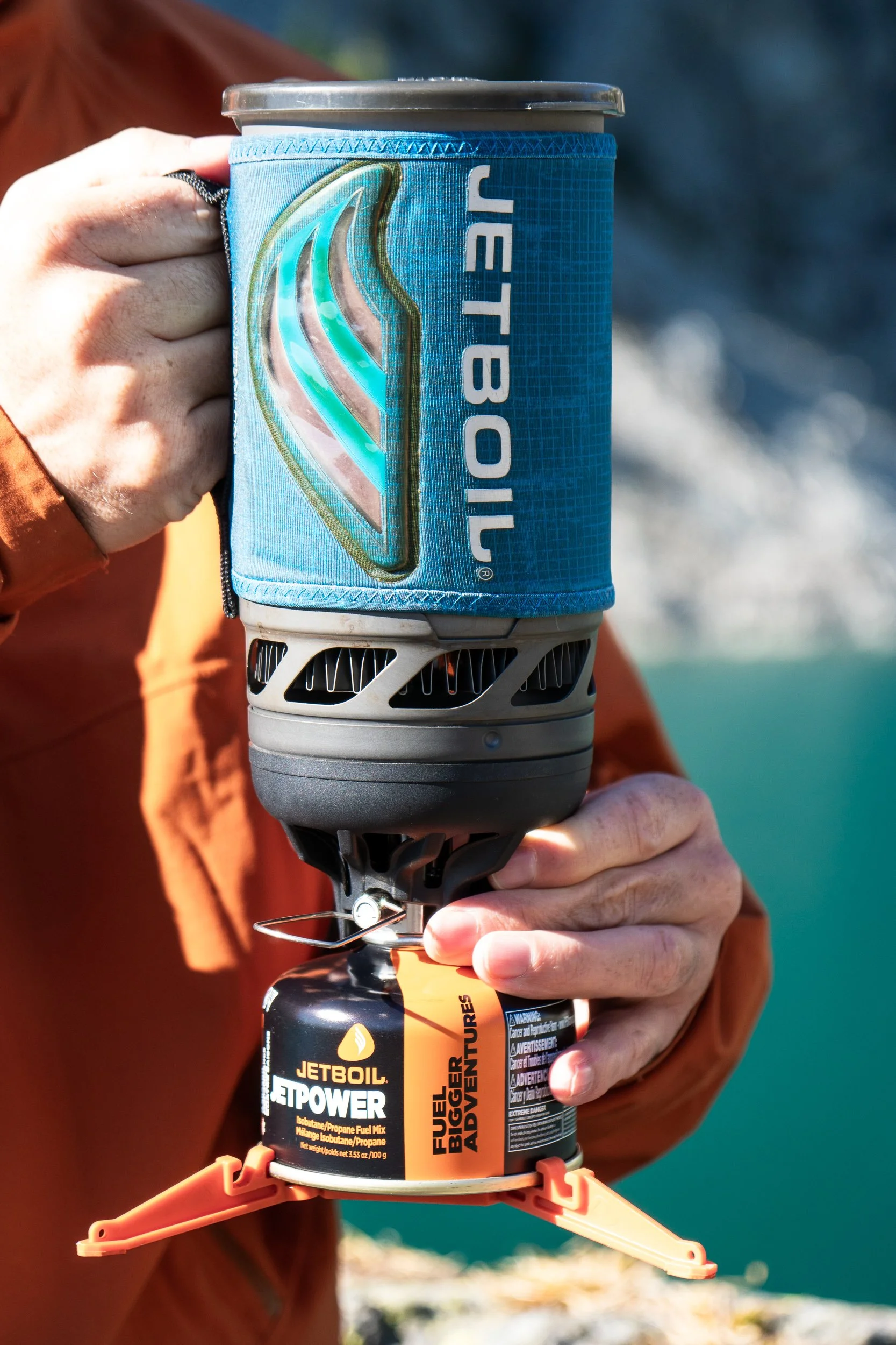  holding a Jetboil stove all-in-one system stove in the mountains 
