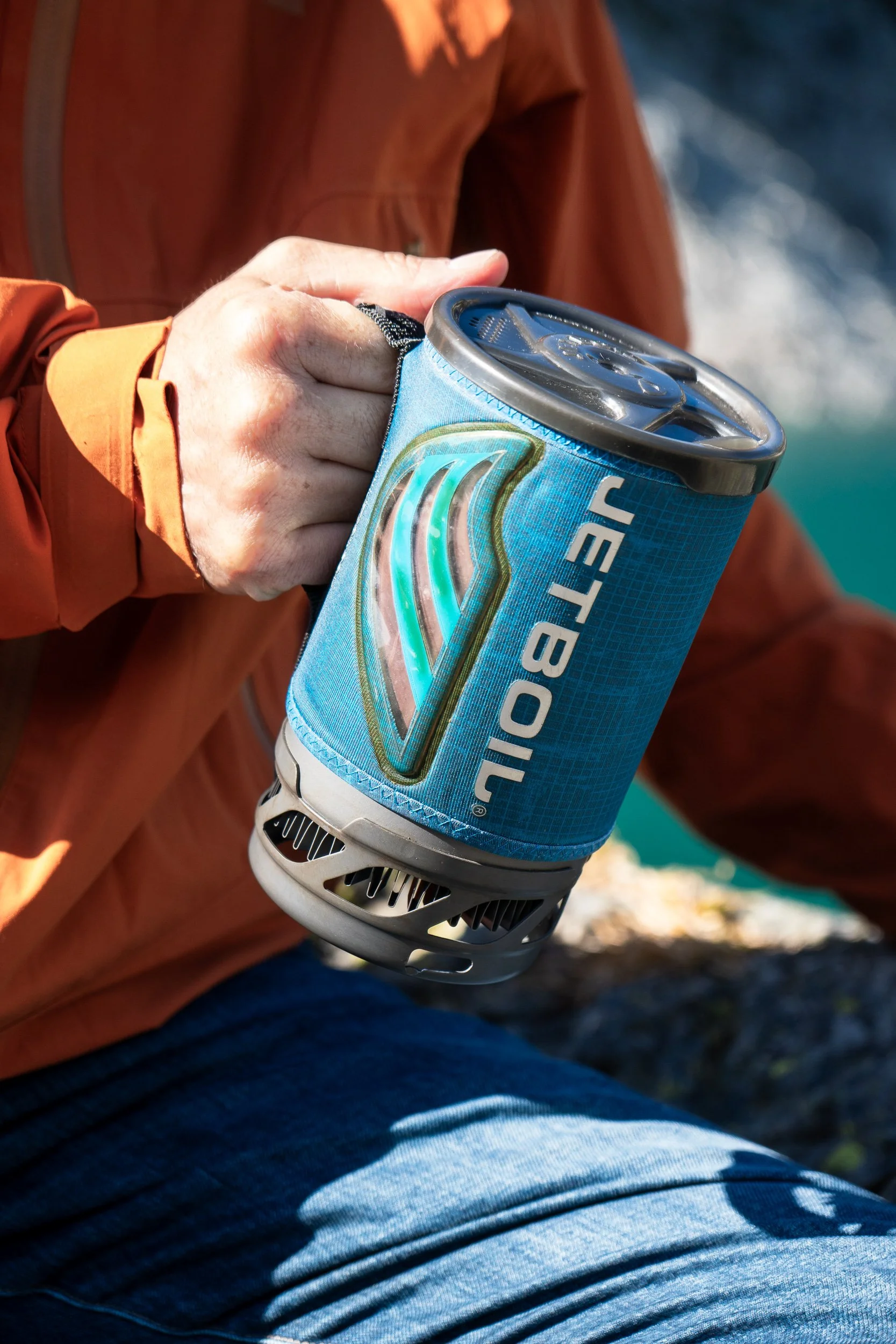  holding a Jetboil stove all-in-one system stove in the mountains 