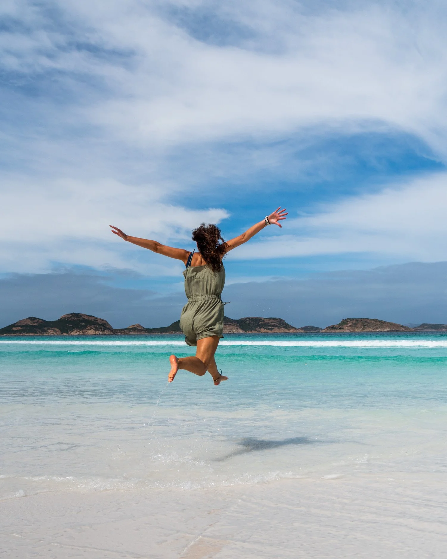 Jumping in the air on the white sands of Lucky Bay in Australia