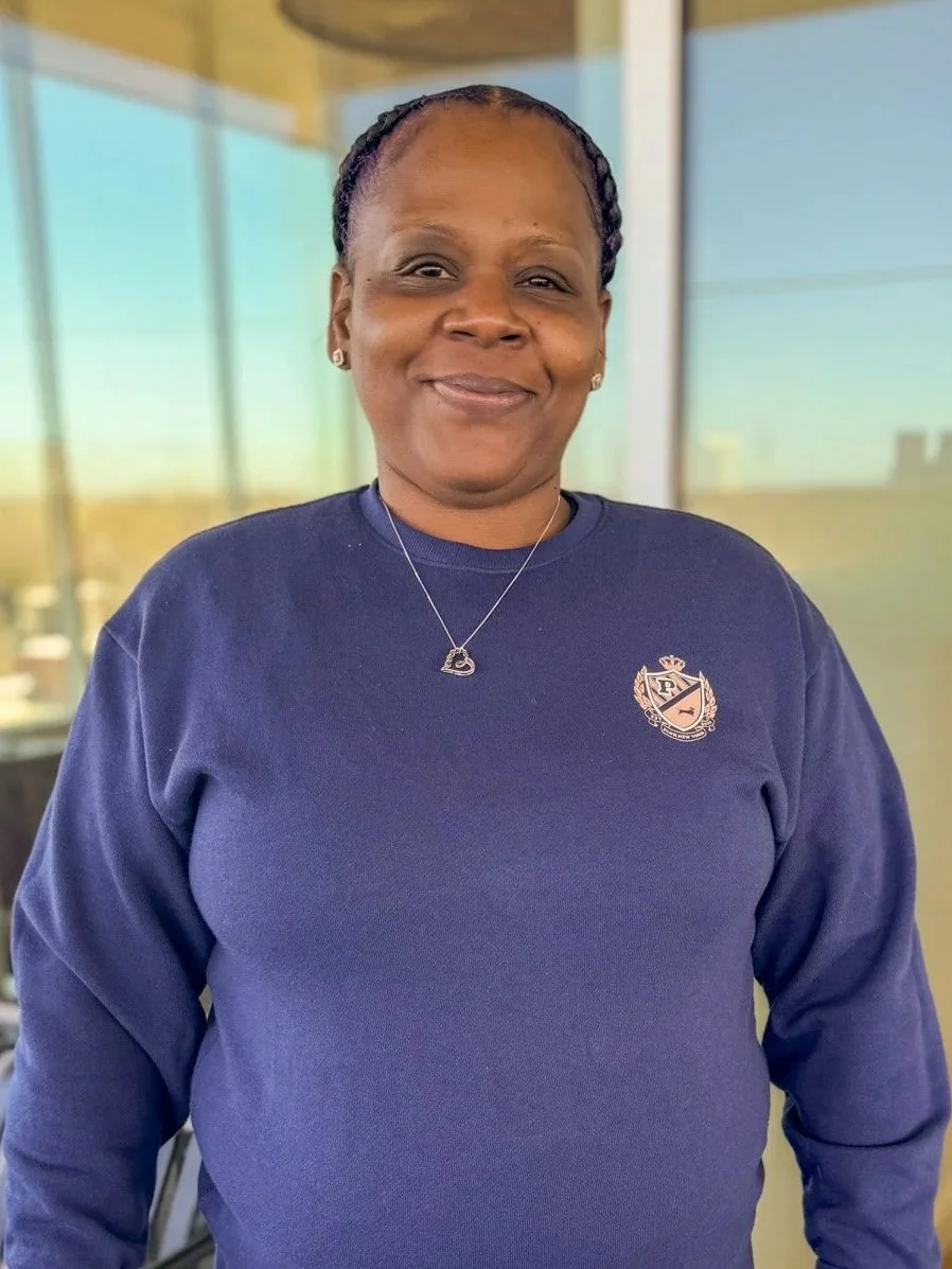 Headshot of woman smiling at the camera, wearing blue sweatshirt