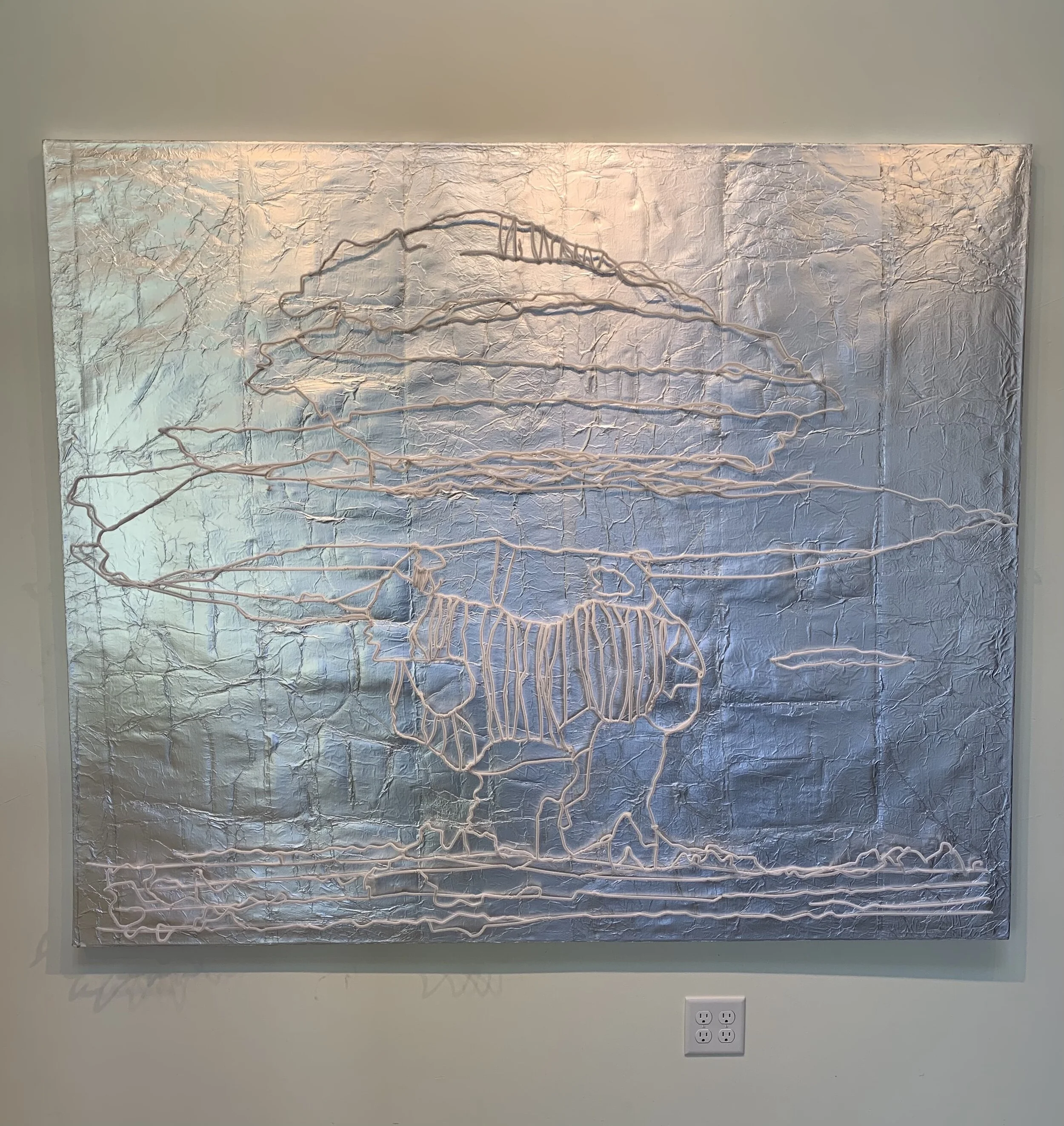 Metal wall art depicting a bald eagle with a mountain and sky background, created with curved metal lines.