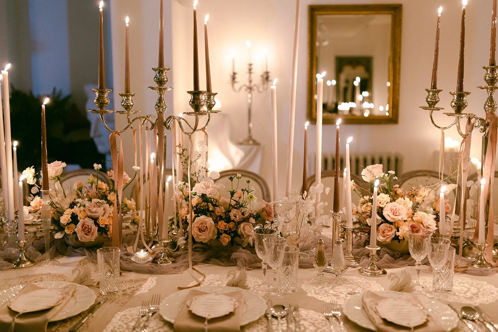 Candlelit December wedding dinner styled with layered florals and candles