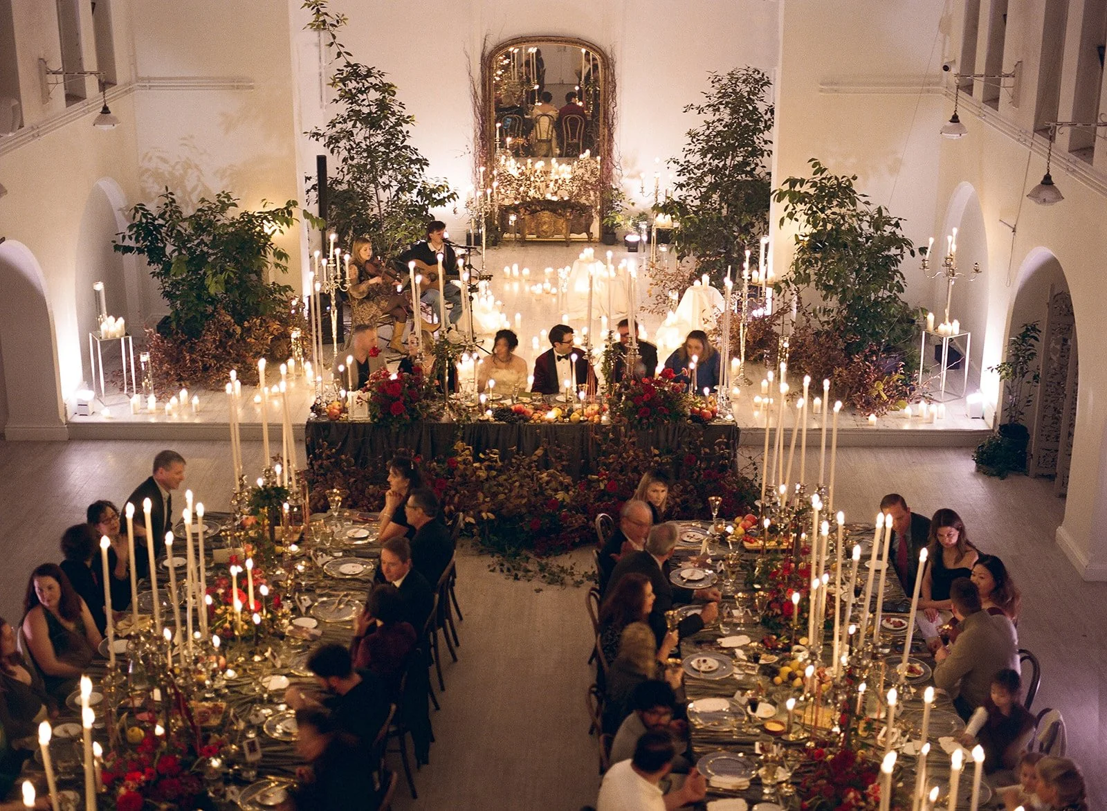 wedding rehearsal dinner, dark and moody candlelit long tables in the chapel in gloster House