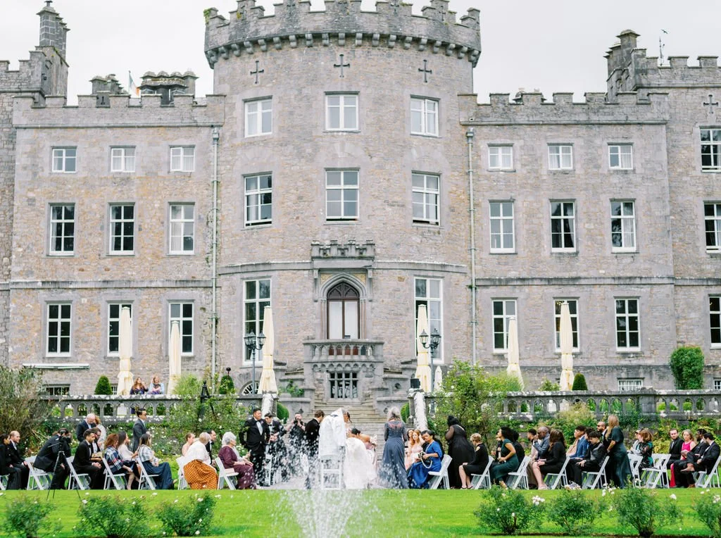 Outdoor wedding ceremony at Markree Castle County Sligo Ireland showing full castle facade fountain and seated guests