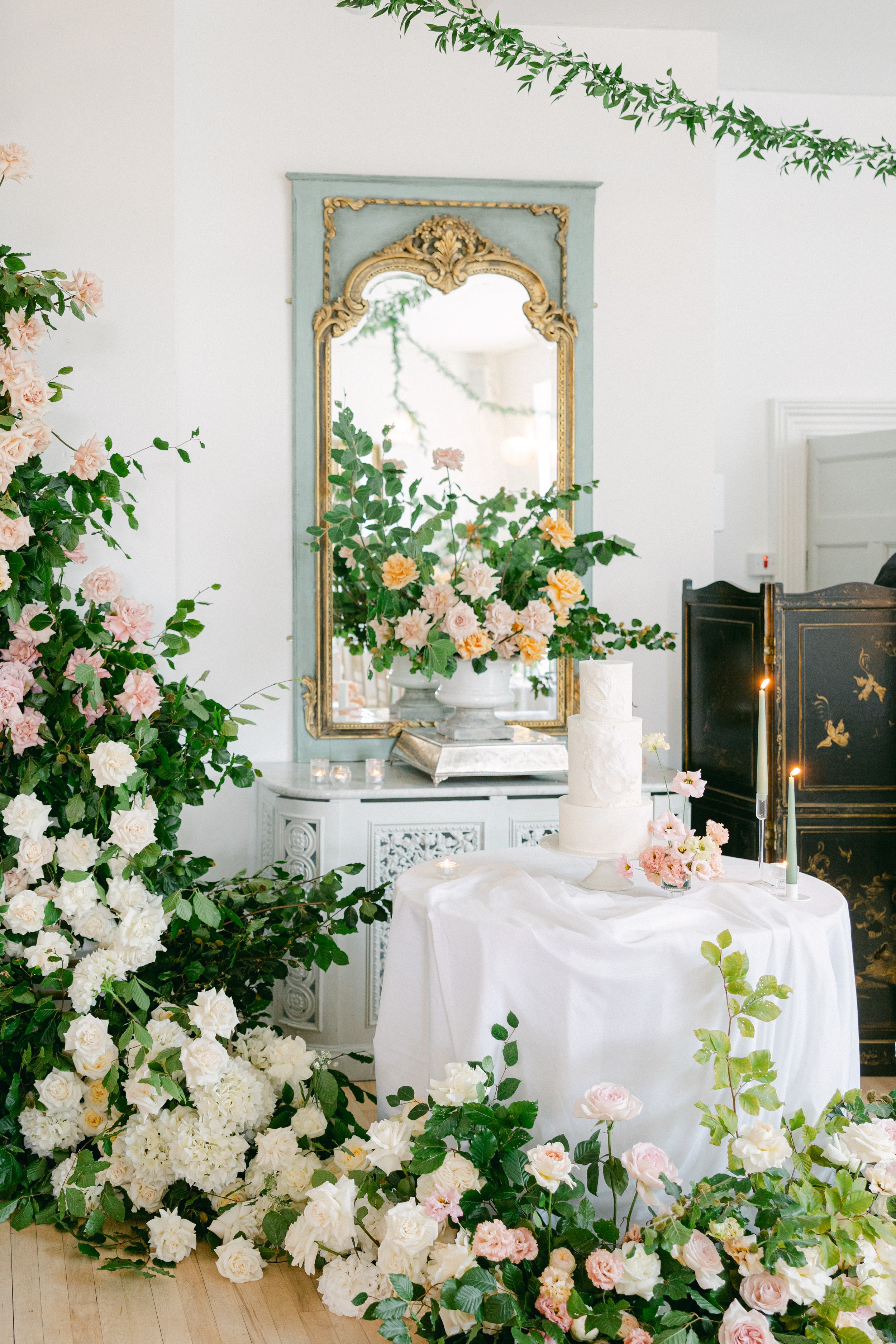 lush summer flowers surrounding a wedding cake