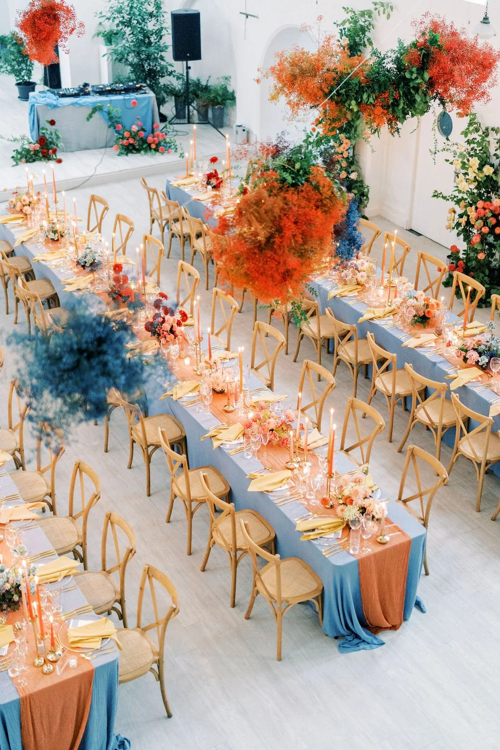 Long vibrant autumn wedding tables with overhead hanging installations