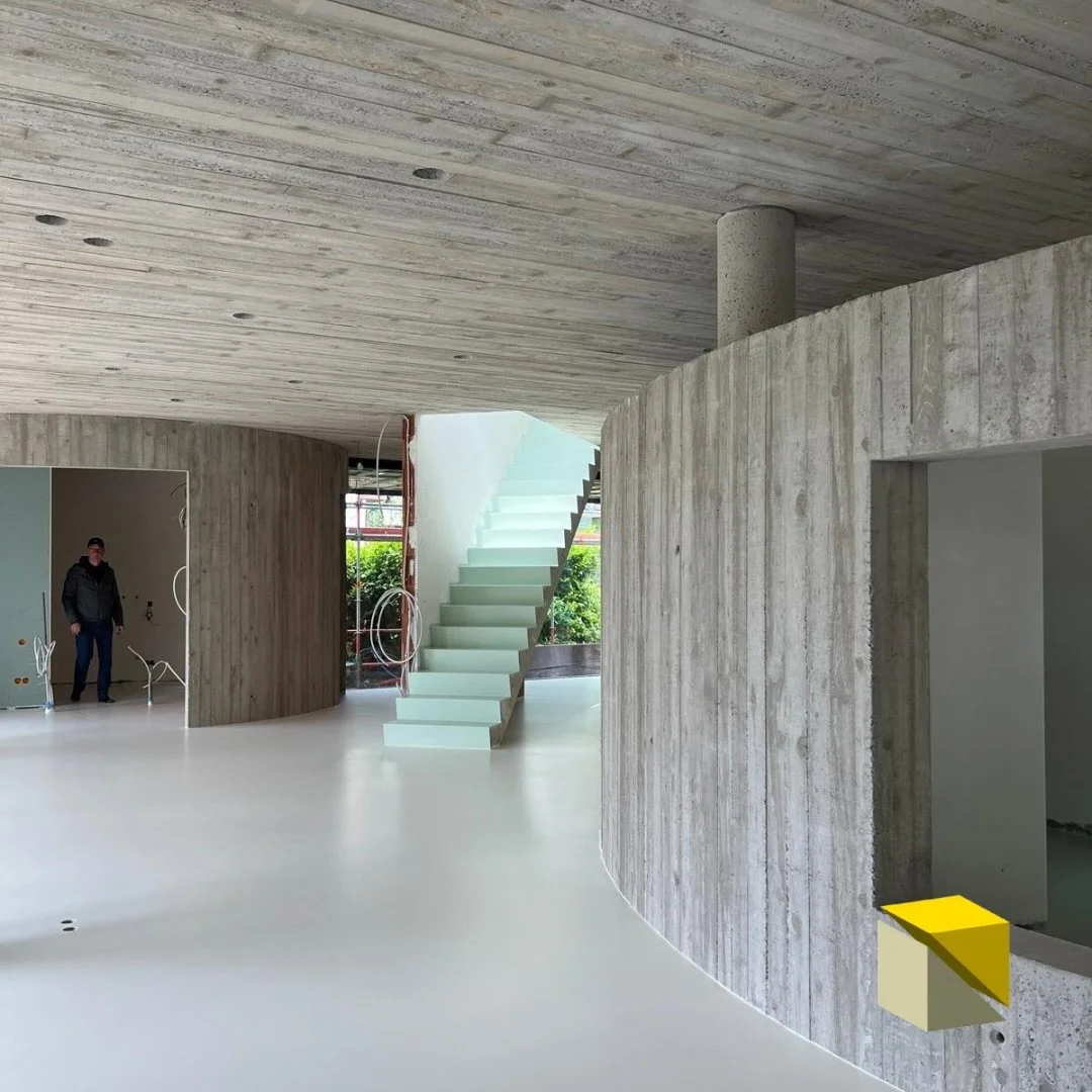 Strakke lijnen, pure materialen en oog voor detail. 
Op deze vrijstaande nieuwbouwwoning in Zemst realiseerden we een combinatie van verticaal en horizontaal zichtbeton, afgewerkt met ingewerkte spots, een naadloze gietvloer en een opvallende groene 