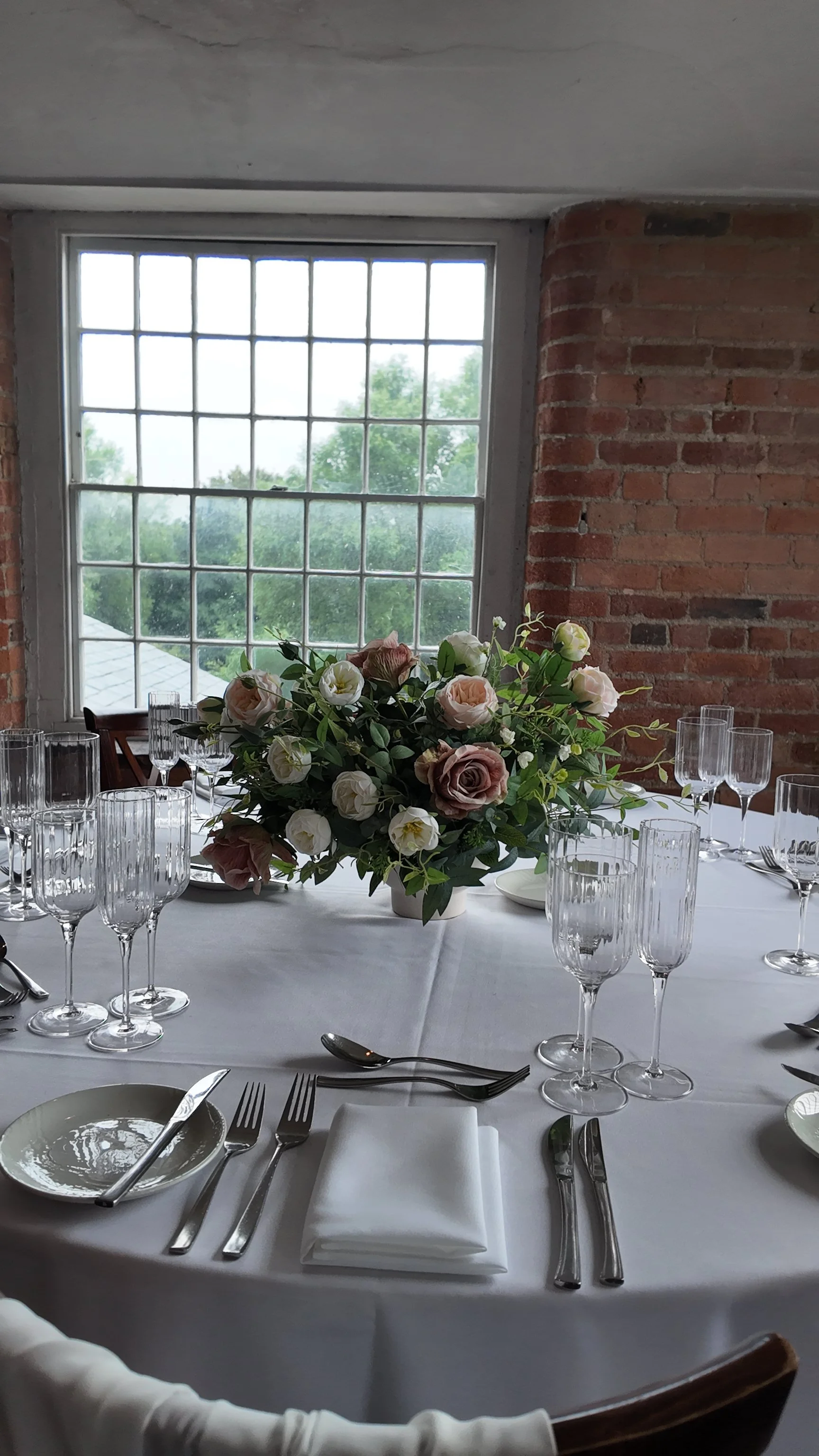 Artificial wedding flower centrepiece with blush roses, white flowers and foliage at The West Mill Derbyshire