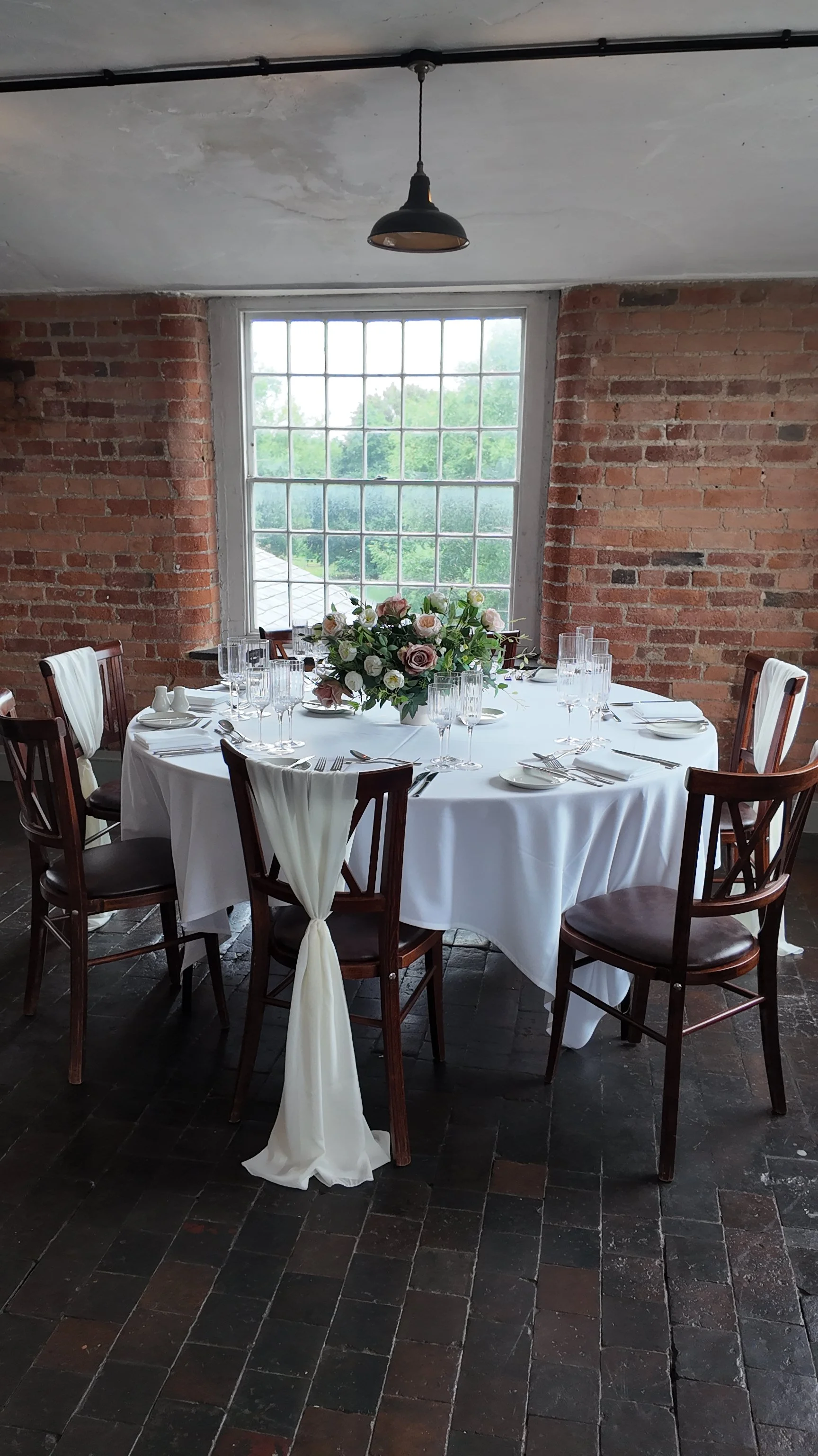 Round wedding breakfast table with blush artificial floral bowl centrepiece at The West Mill Derbyshire