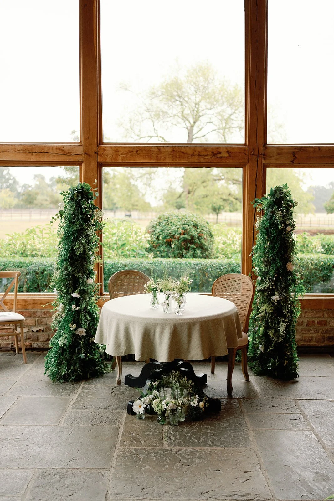 Artificial wedding ceremony flower pillars at Barns and Yard wedding venue