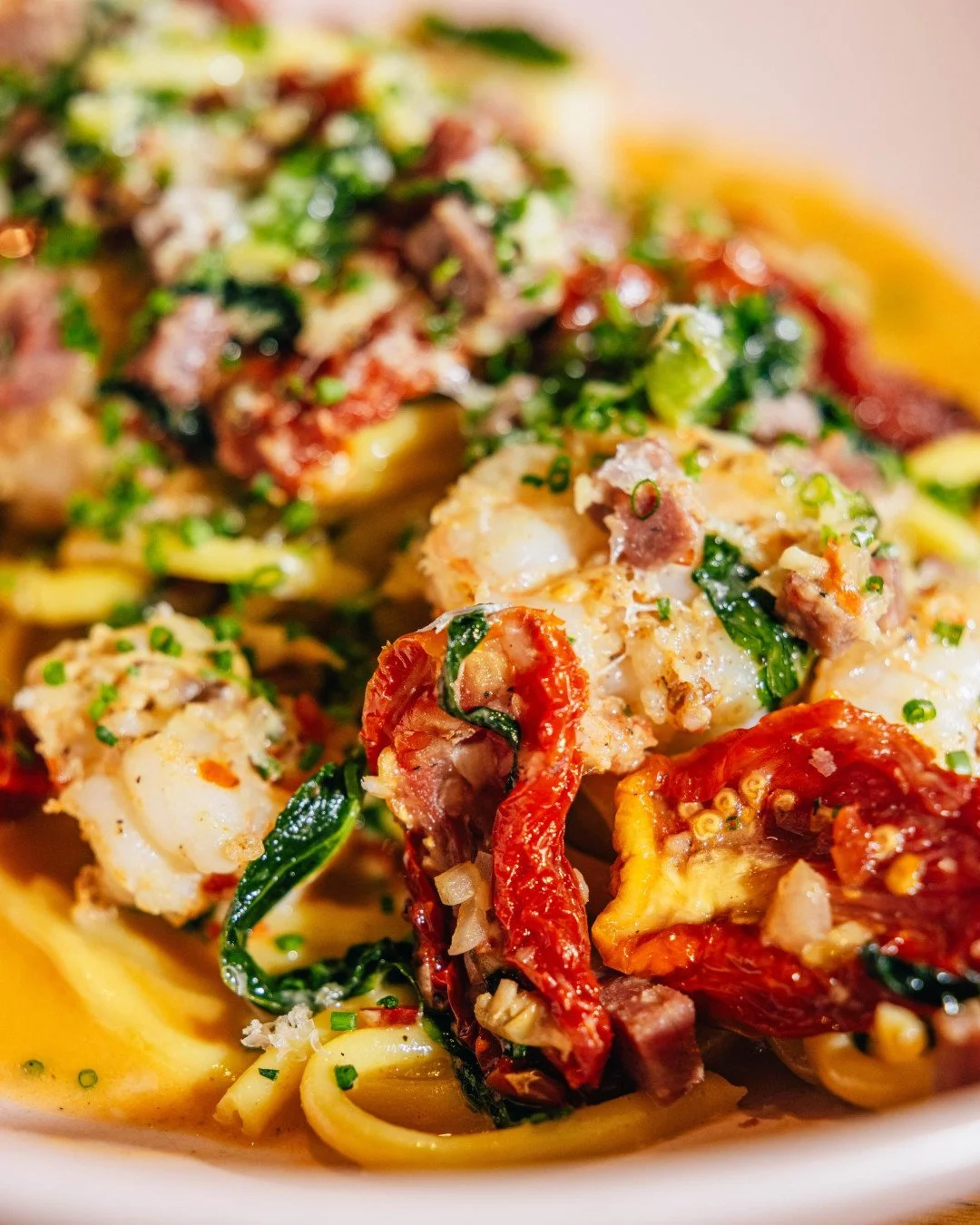 A glorious, twirl-worthy pile of bucatini loaded with shrimp, soppressata, wilted greens, cherry tomato, Calabrian chili, limoncello, and pecorino. Every bite hits.