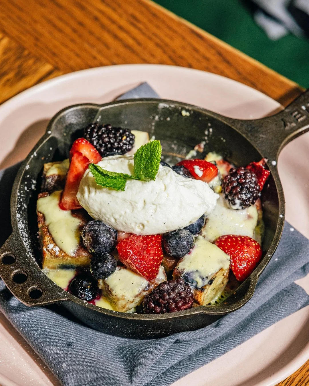 Bread pudding is the kind of comfort classic that never goes out of style. Ours comes rich and custardy, loaded with macerated mixed berries, and finished with silky cr&egrave;me anglaise + even more fresh berries. Served warm in @smitheyironware and