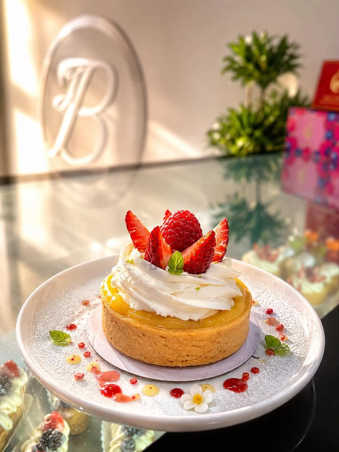 Our Creamy Lemon Tart features a buttery, flaky pastry filled with smooth, refreshing lemon cream and topped with light whipped cream and fresh strawberries—a perfect balance of creamy, sweet, and tangy flavors in every bite.