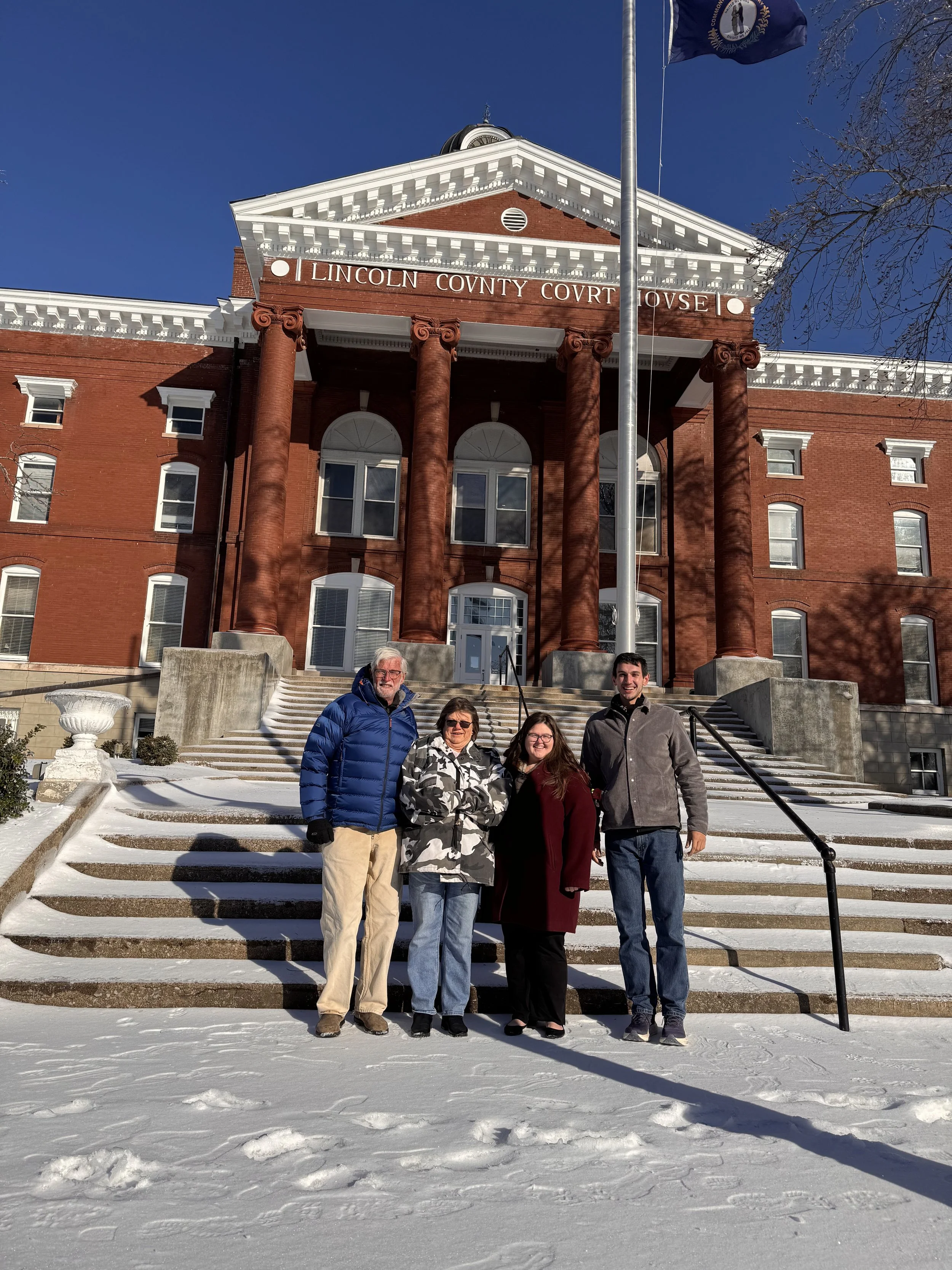 four people outside a courthouse