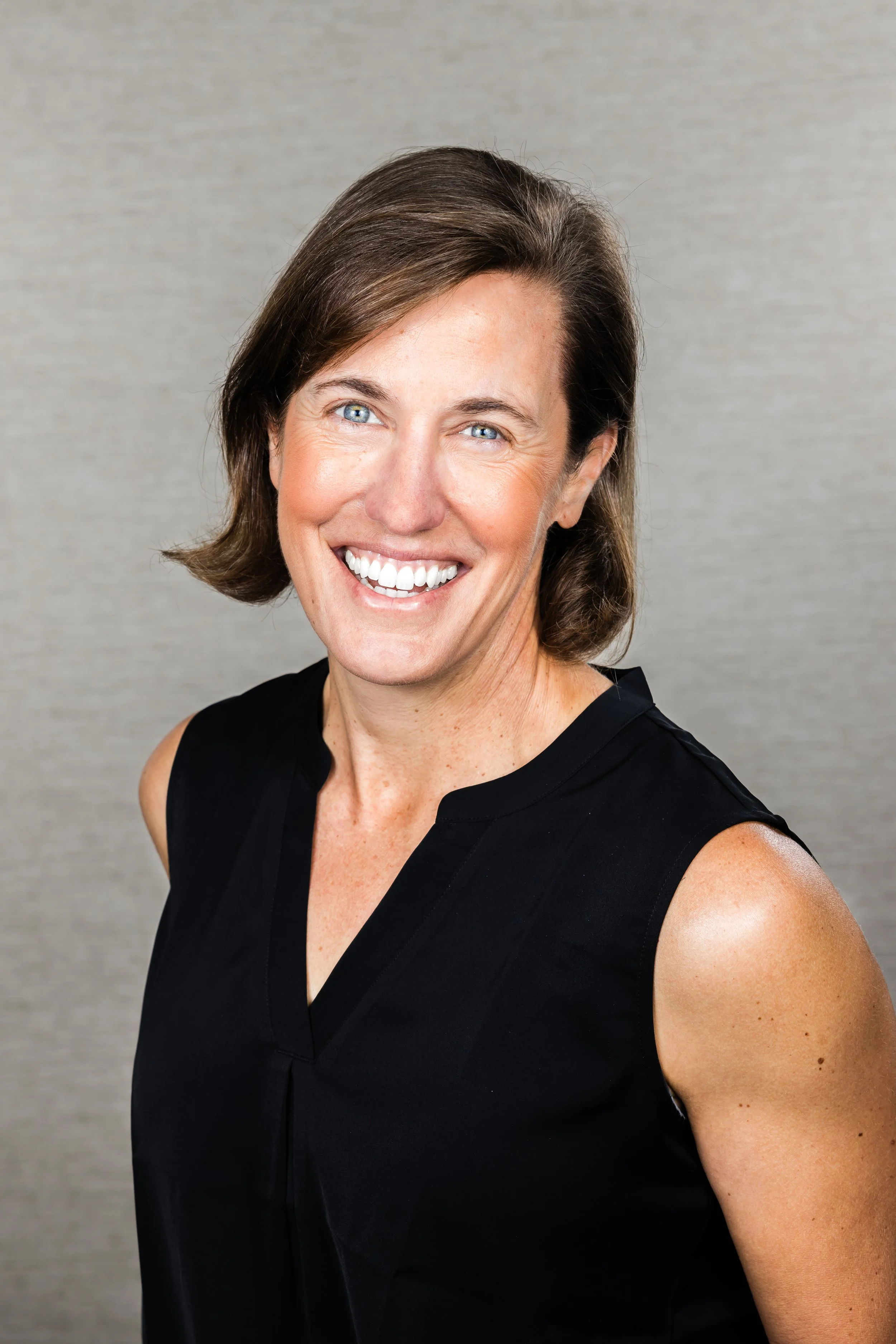 Lizzie Merritt in a black sleeveless shirt smiling