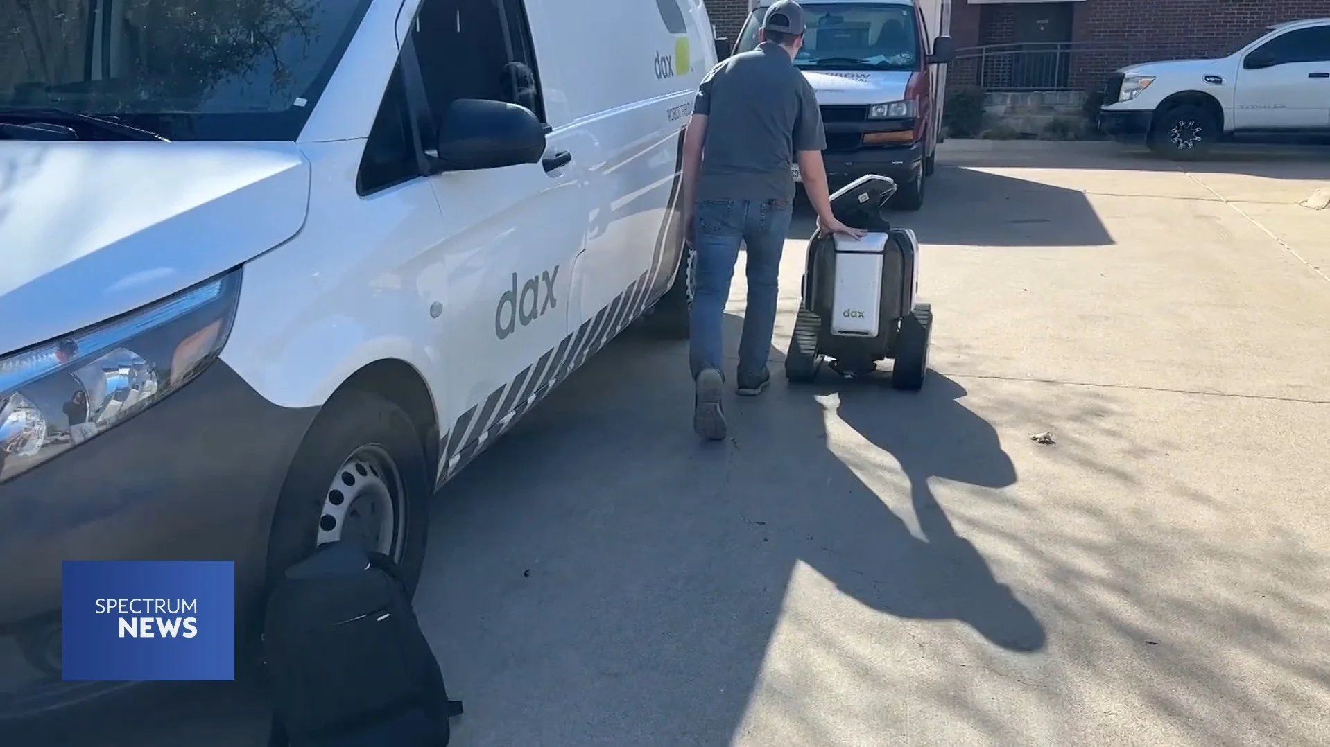 Daxbot employee moves robot into back of Dax van