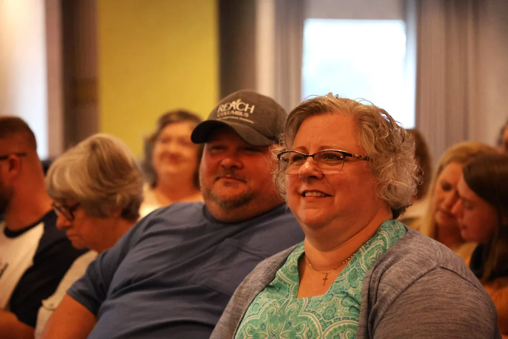  Audience at event sitting in chairs.  