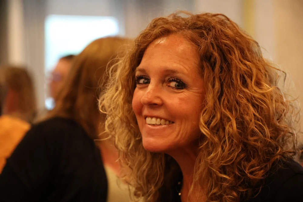  Smiling woman with curly red hair.  