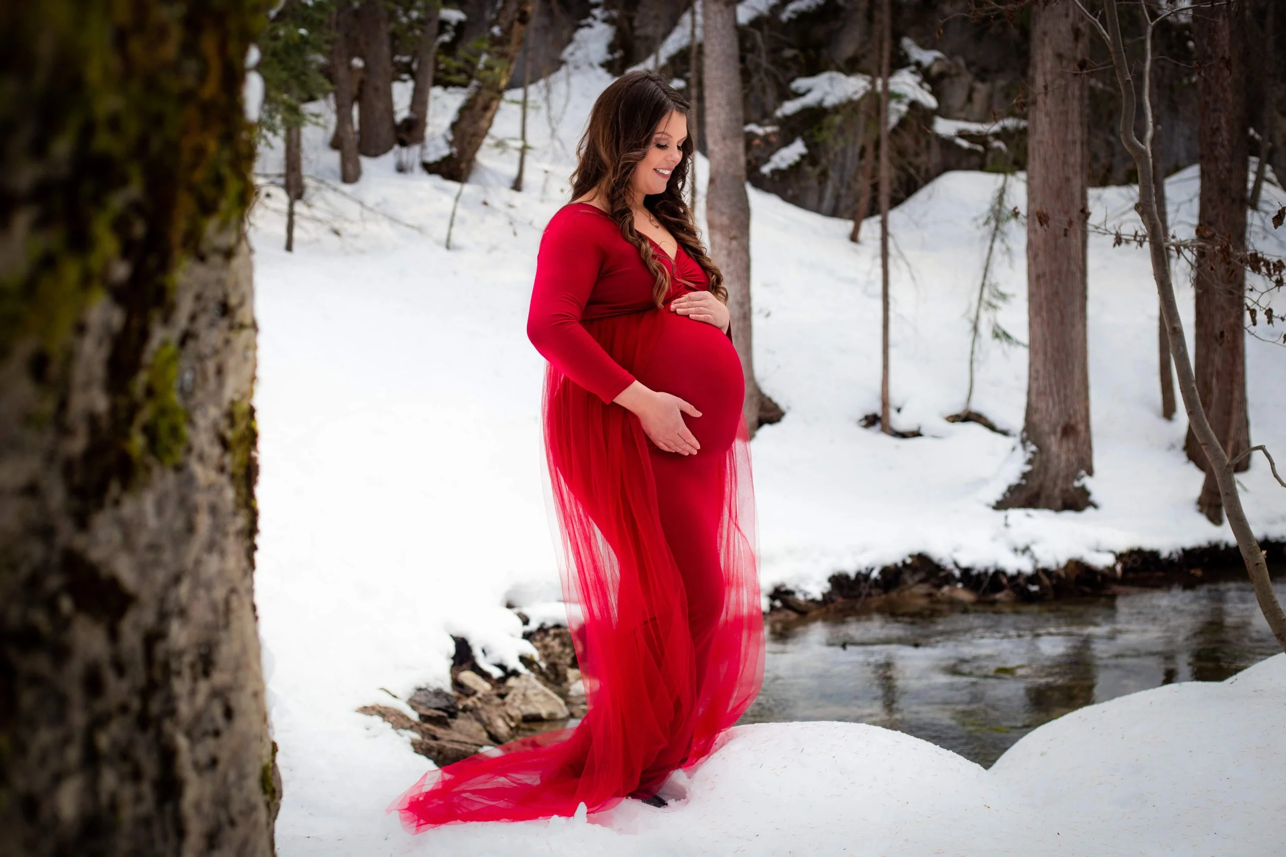A woman poses for maternity photos in Jasper National Park, photo by Jasper Photographer Megan Posein