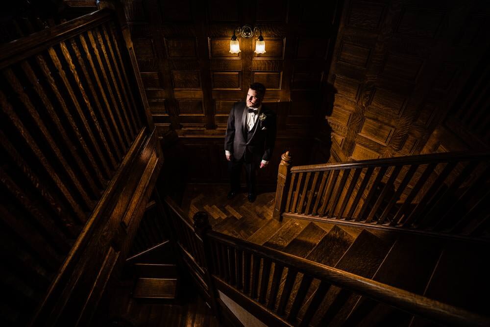  Groom on the stairs - Tapestry House winter wedding by Fort Collins wedding photographer, JMGant Photography 