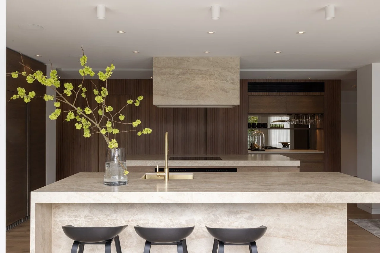 Eternodesigned kitchen with a marble island, with dark wood cabinets and a neutral color palette.