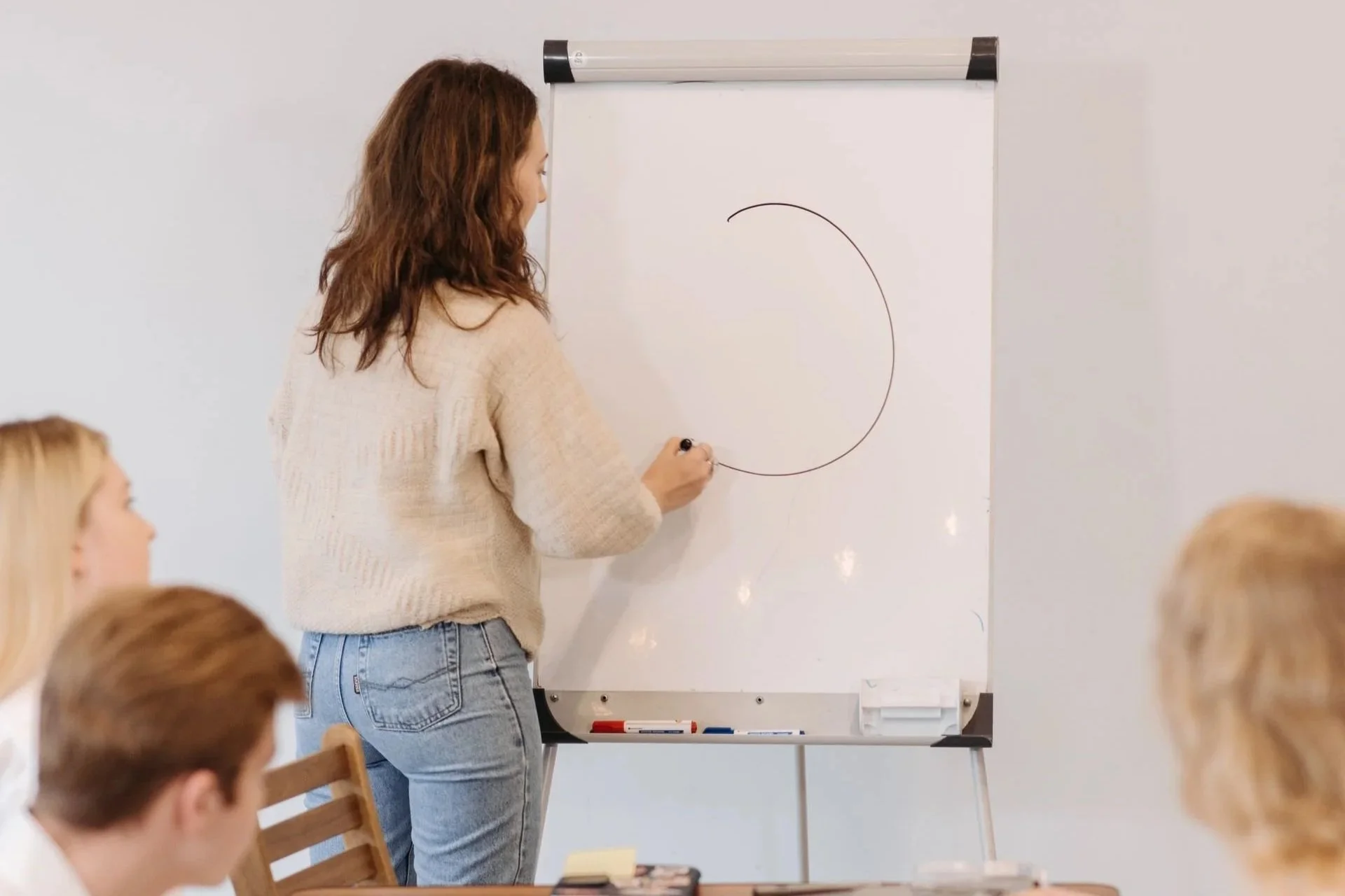 Vrouw tekent op een flipchart tijdens een workshop over webdesign regels die een website prettiger in gebruik maken