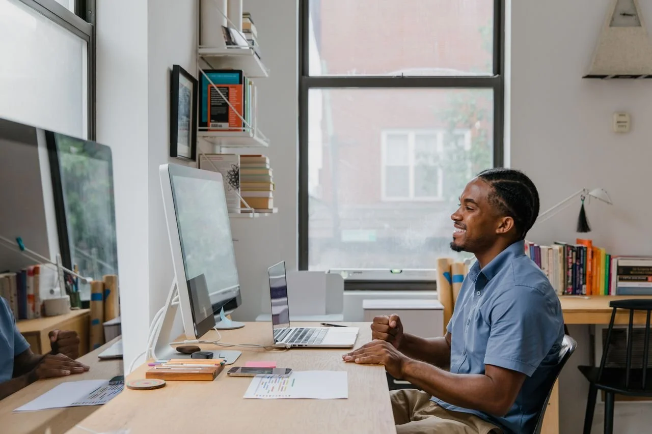 Blije ondernemer bekijkt het resultaat van zijn professioneel ontworpen Squarespace website op een computerscherm