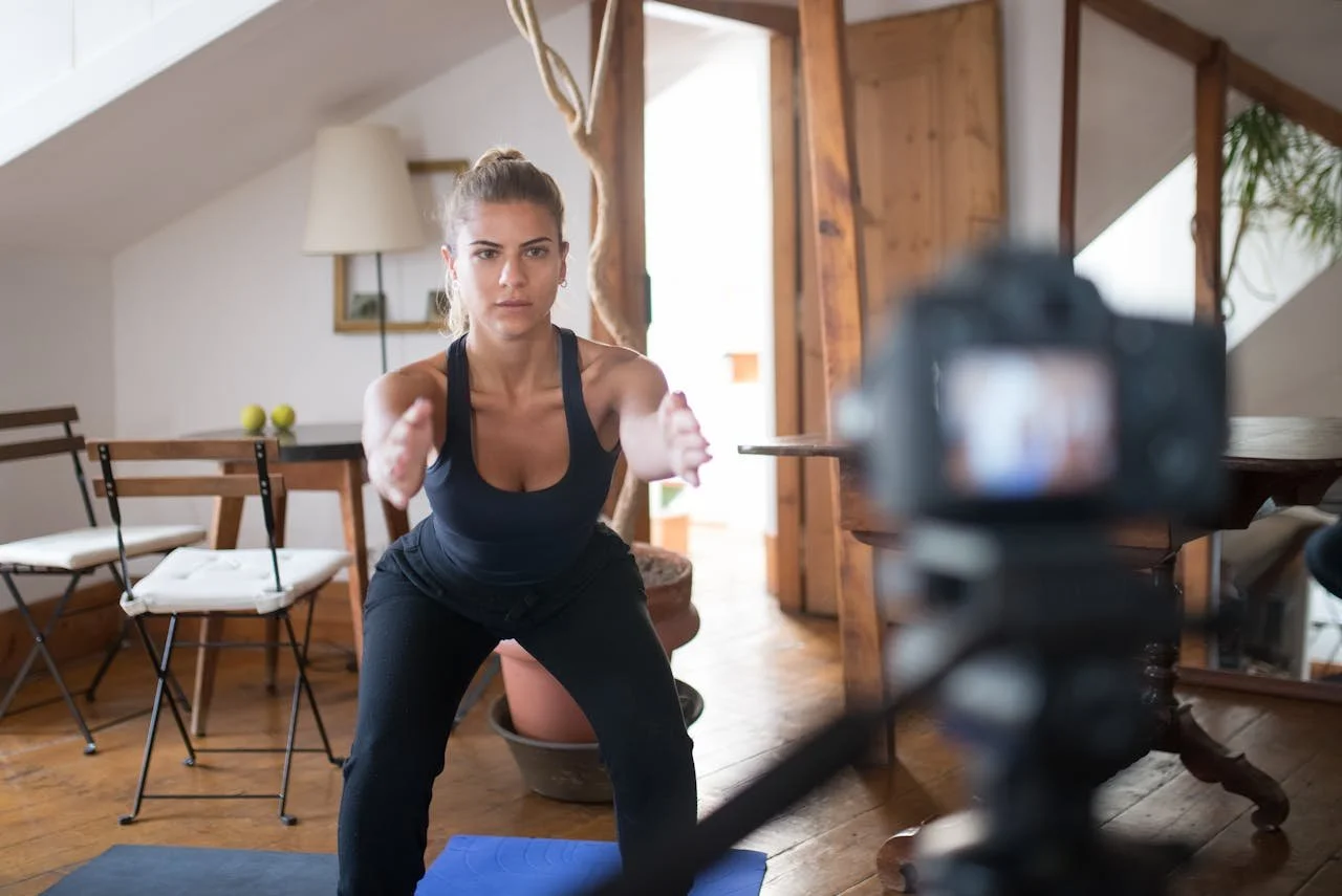 Een online yoga coach geconcentreerd bij de opname voor haar online cursus op haar coach website