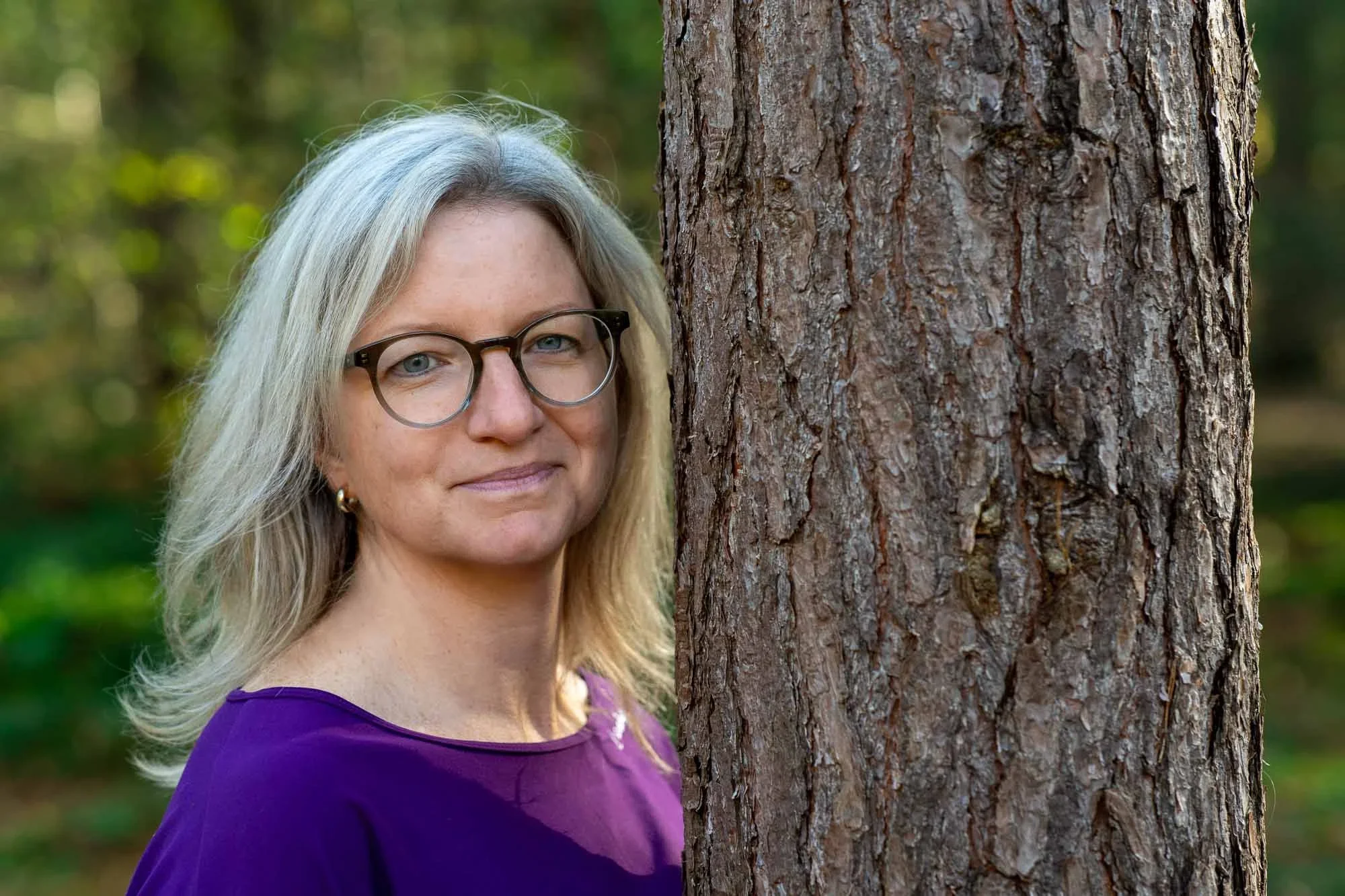 Marieke, natuurcoach uit Breda, glimlacht in de camera terwijl ze buiten in een bos staat — reviewfoto bij haar ervaring met Made by Anouk over het maken van haar Squarespace website.