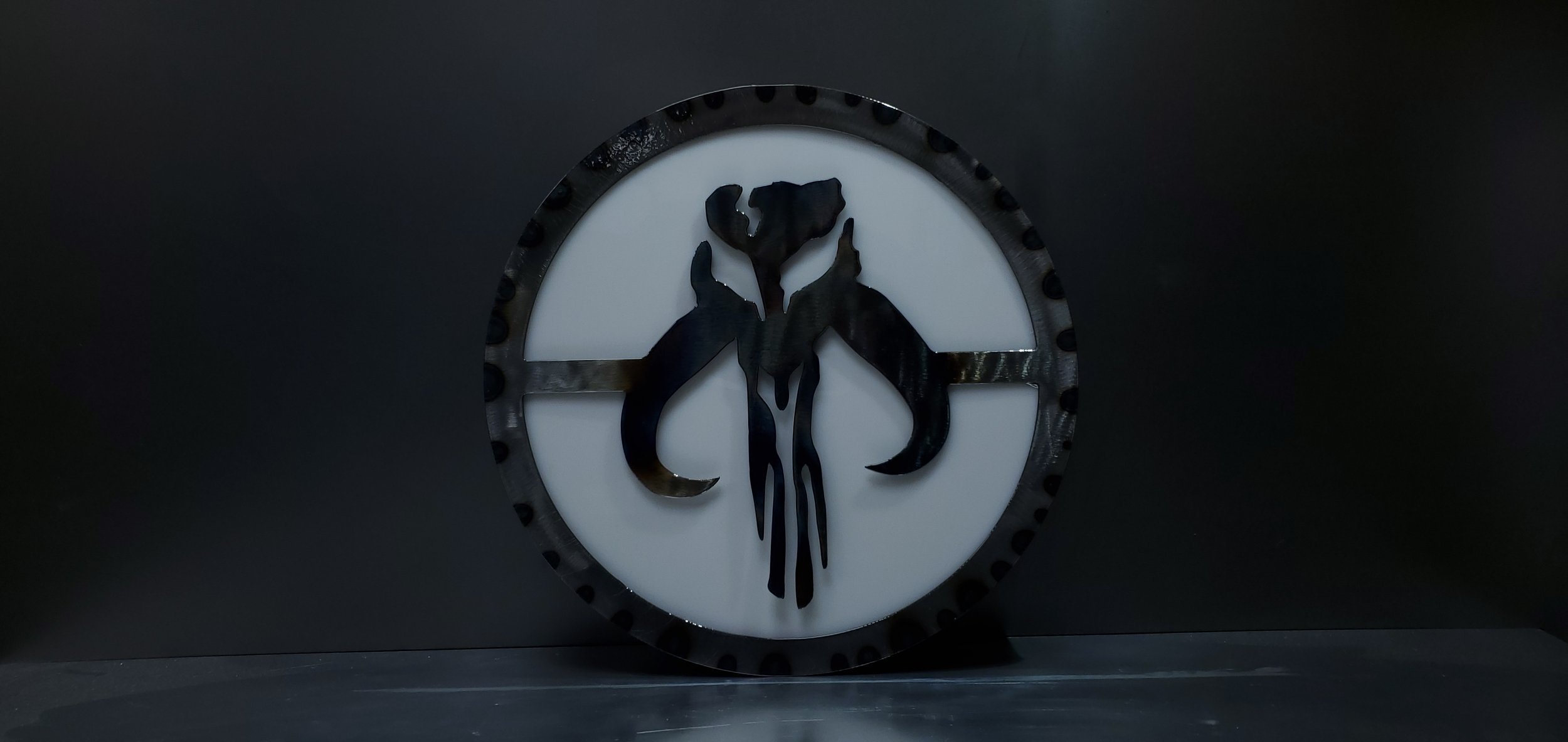 A round wall clock with a black frame, a white face, and a black silhouette of an animal skull in the center.