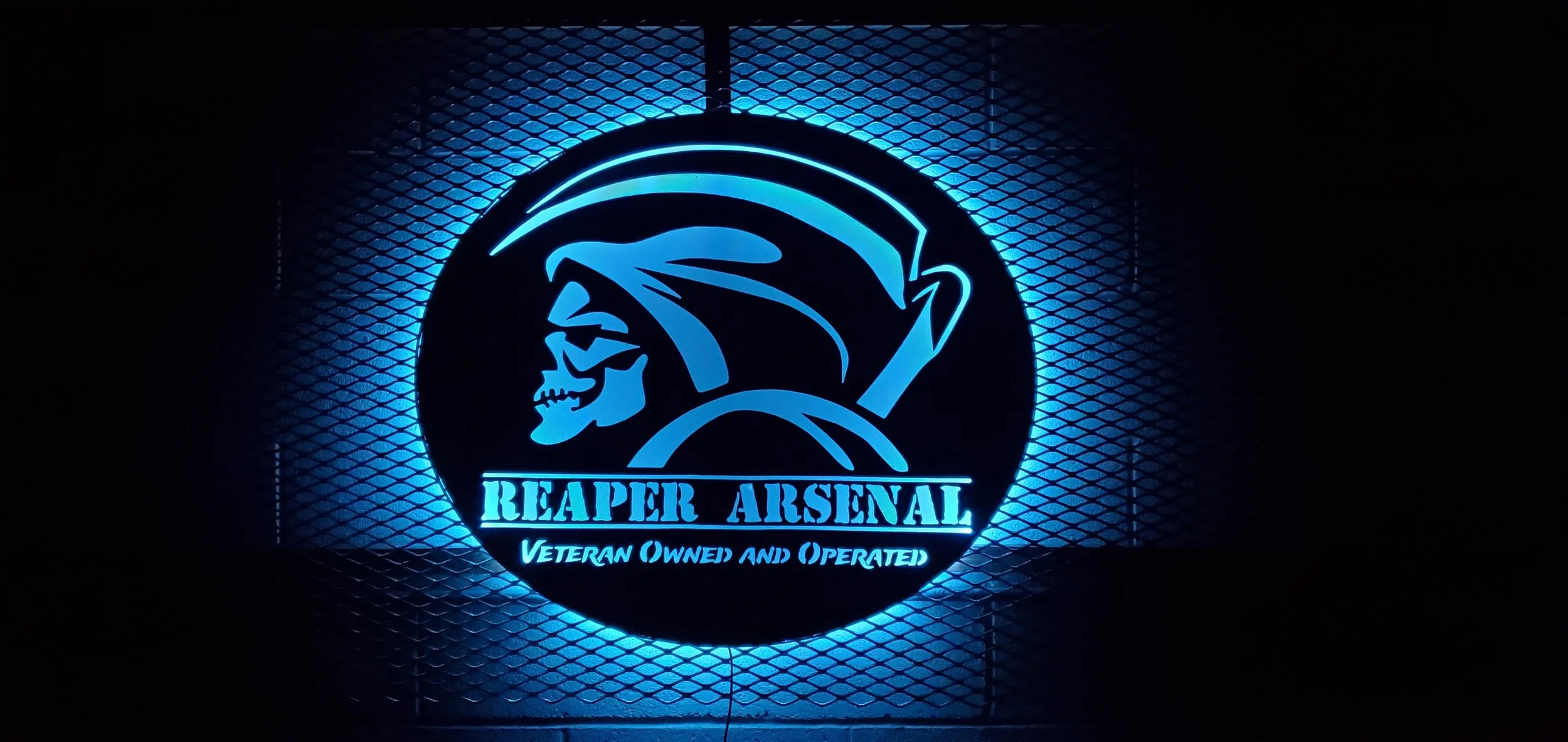 Neon sign for Reaper Arsenal, featuring a skeletal figure in a helmet and glasses, with the text "REAPER ARSENAL" and "Veteran Owned and Operated" underneath, illuminated in blue against a dark background.