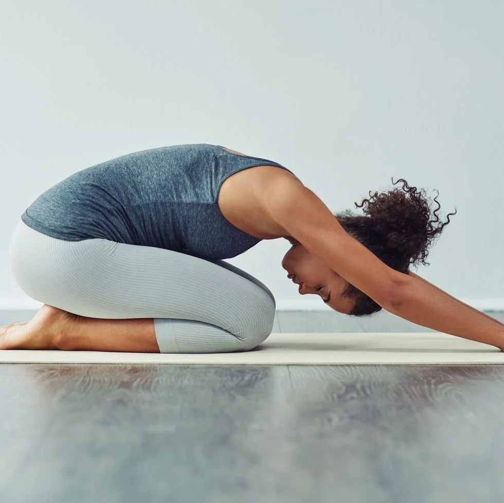Women stretching in child's pose on yoga mat
