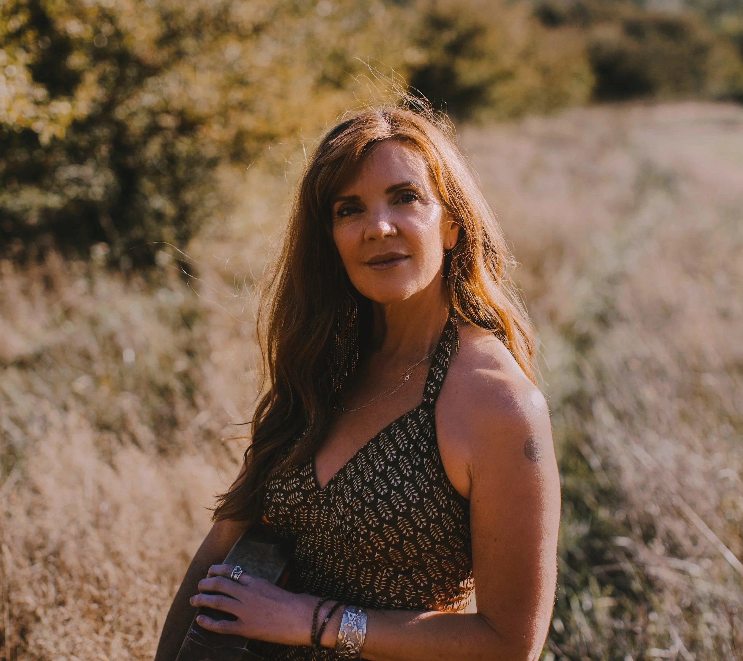 Angela Prider standing with shamanic drum in Nature