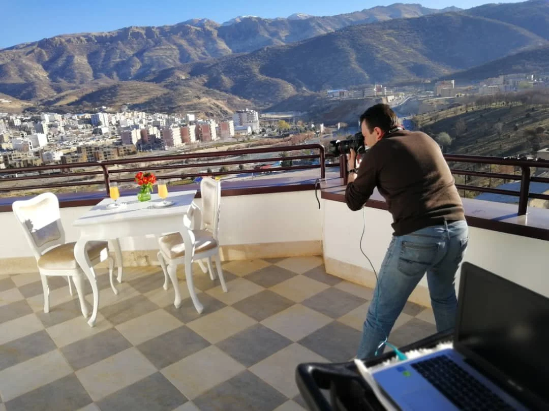 Changiz Jalayer, professional photographer, shooting on a rooftop terrace with mountain view