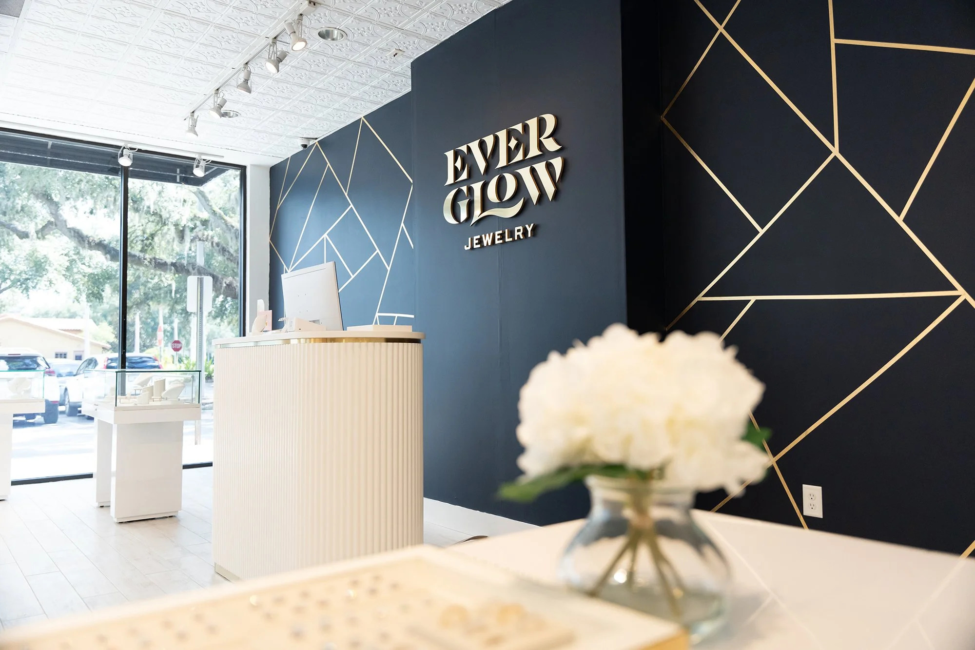 interior store of Everglow Jewelry showcasing cash register and wall mural