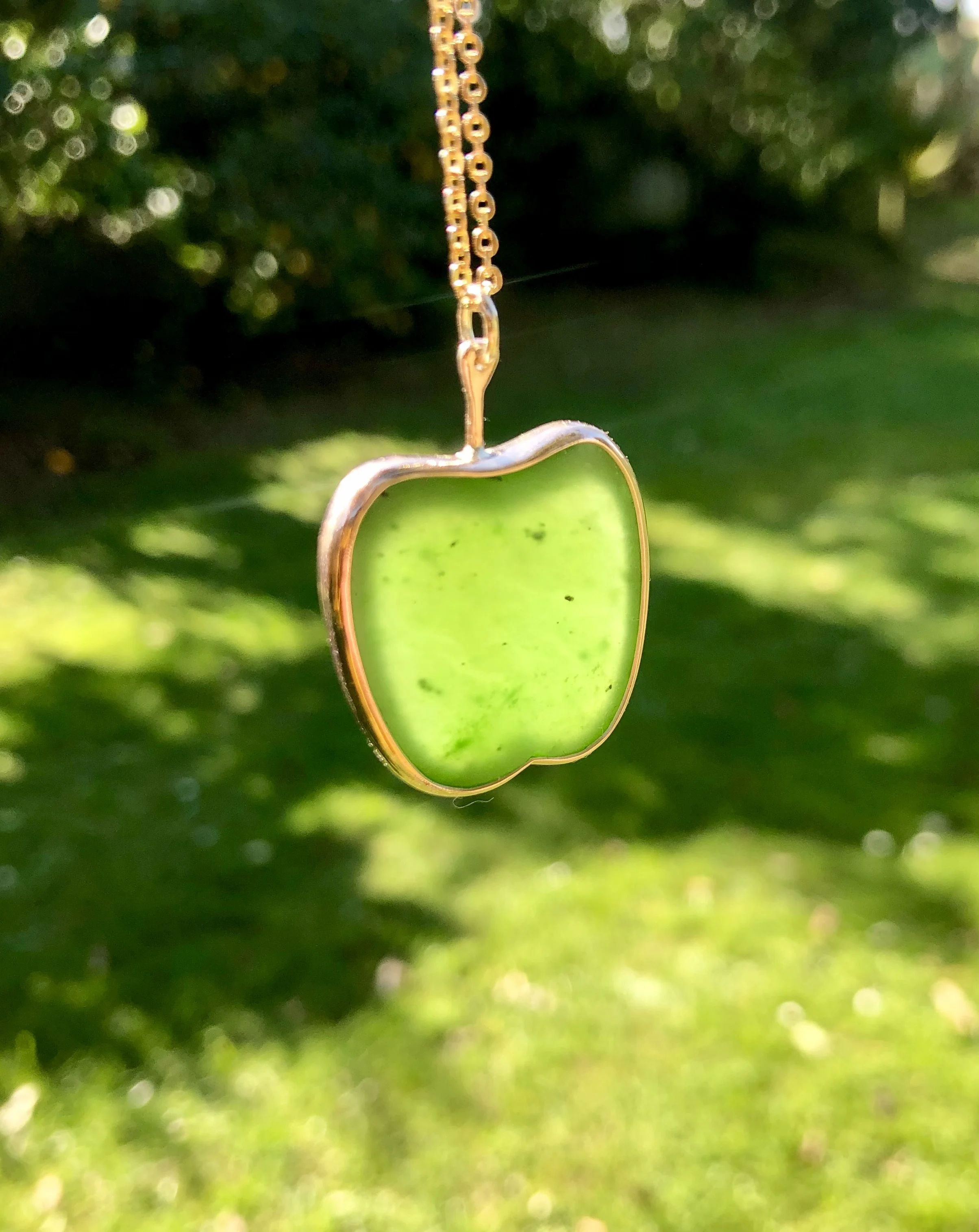 Side view of golden apple shown in the sunlight to emphasise pounamu colour.