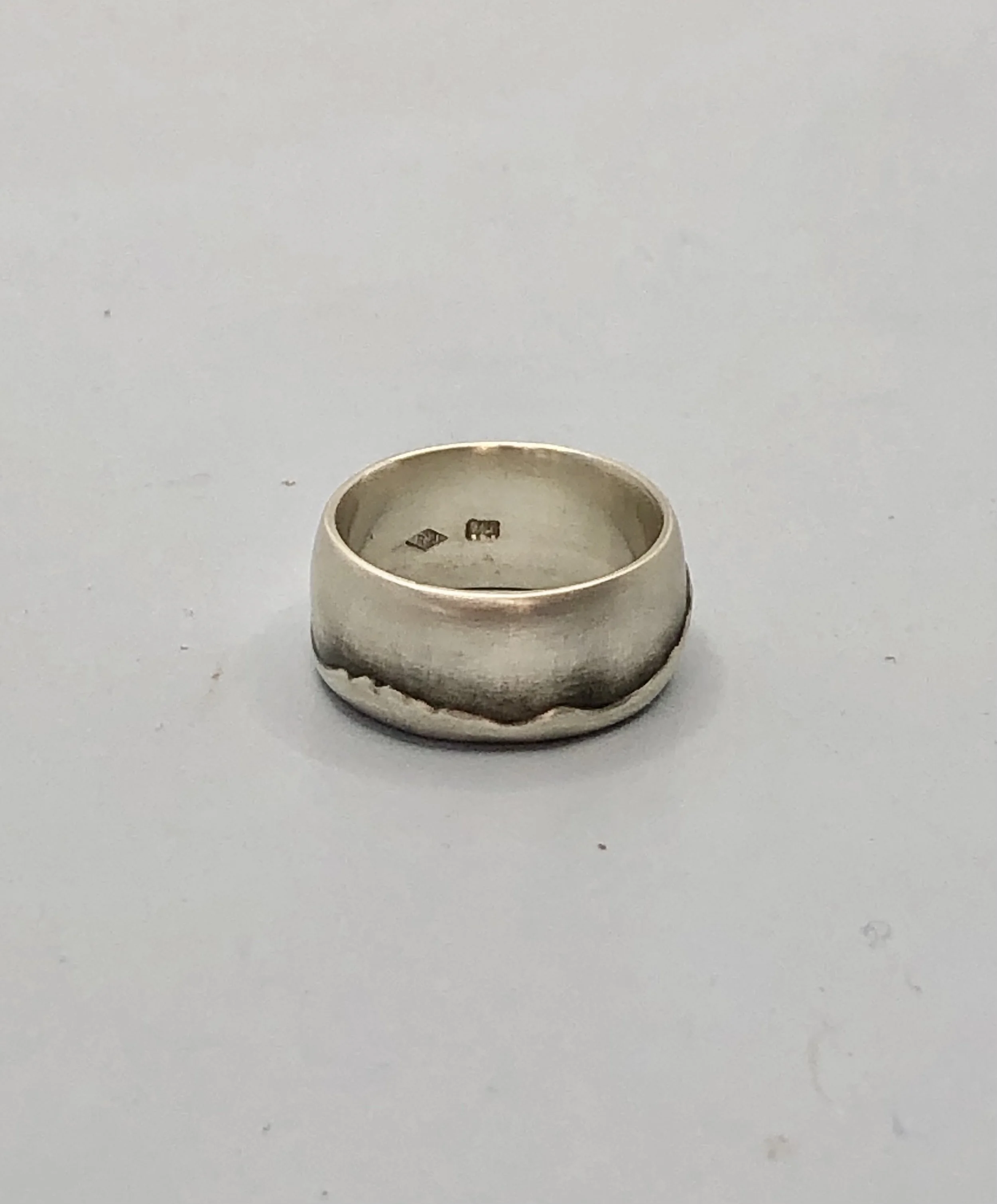 Side profile of Taranaki ranges ring showing hand-carved mountain skyline in sterling silver