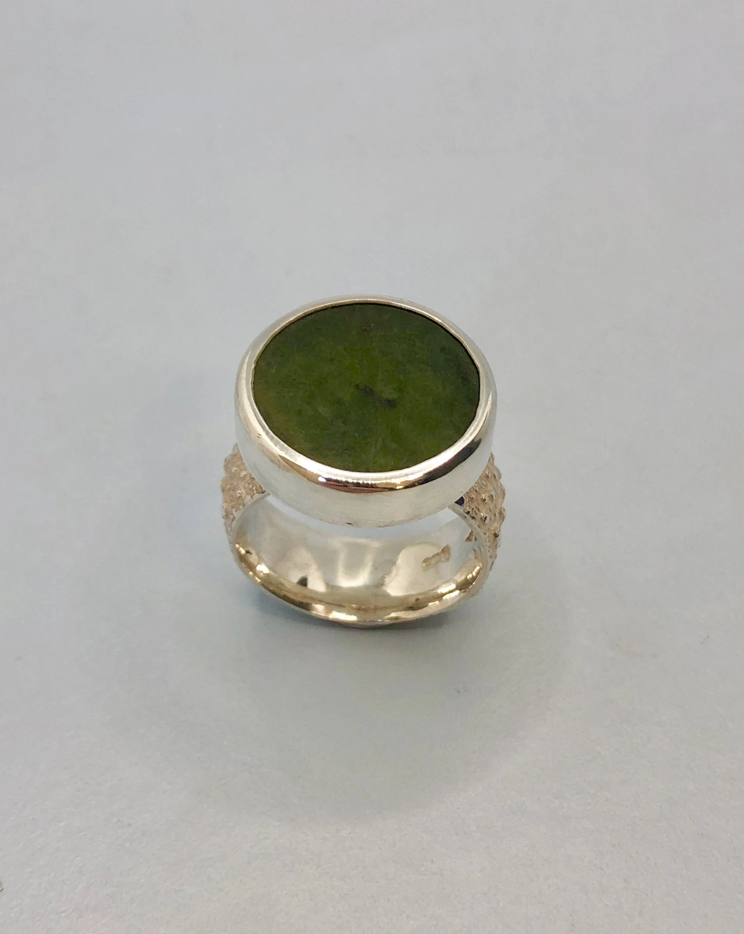 Kina textured ring with NZ pounamu disc set on top