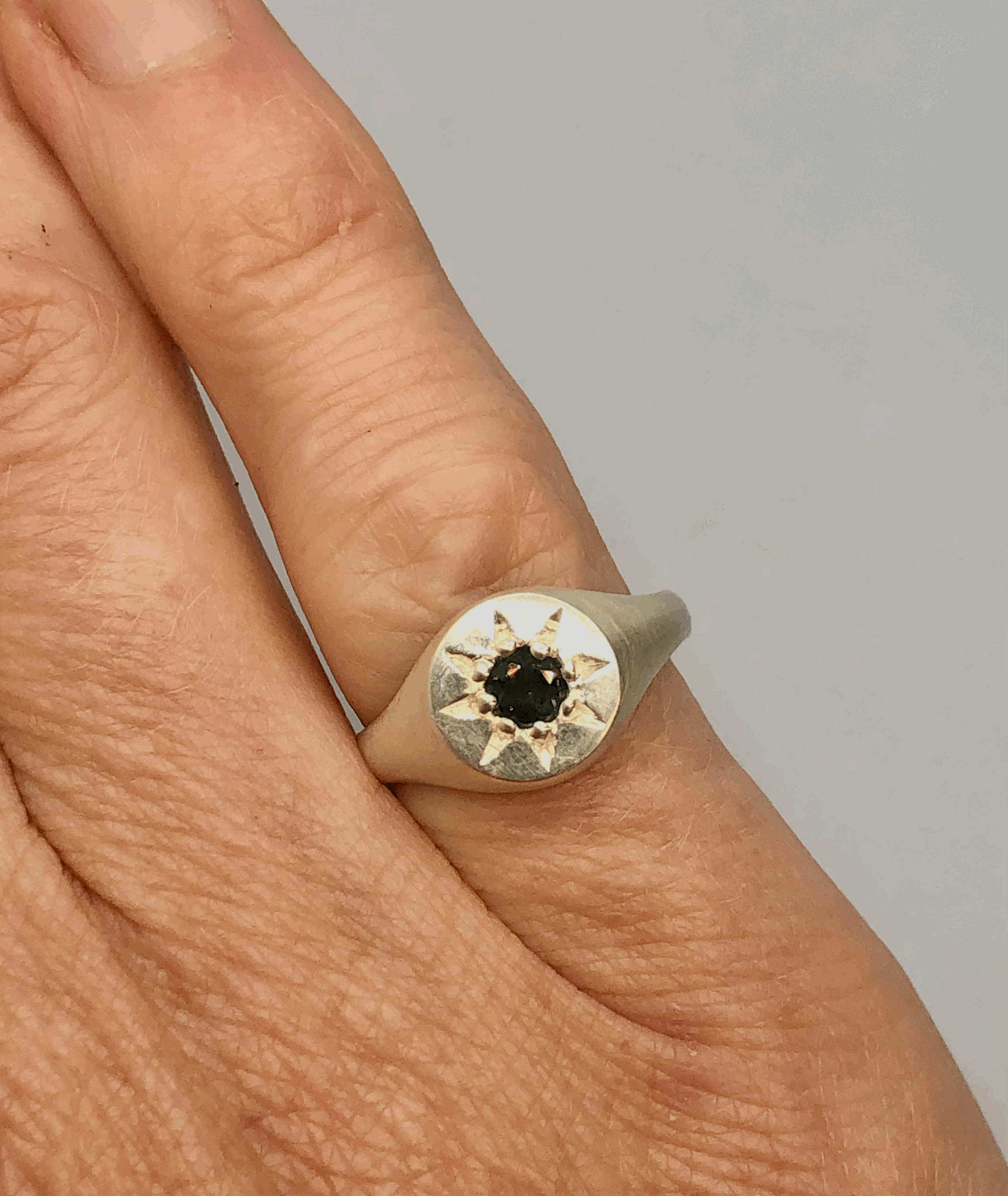 Sapphire silver signet ring worn on pinky finger showing scale and fit