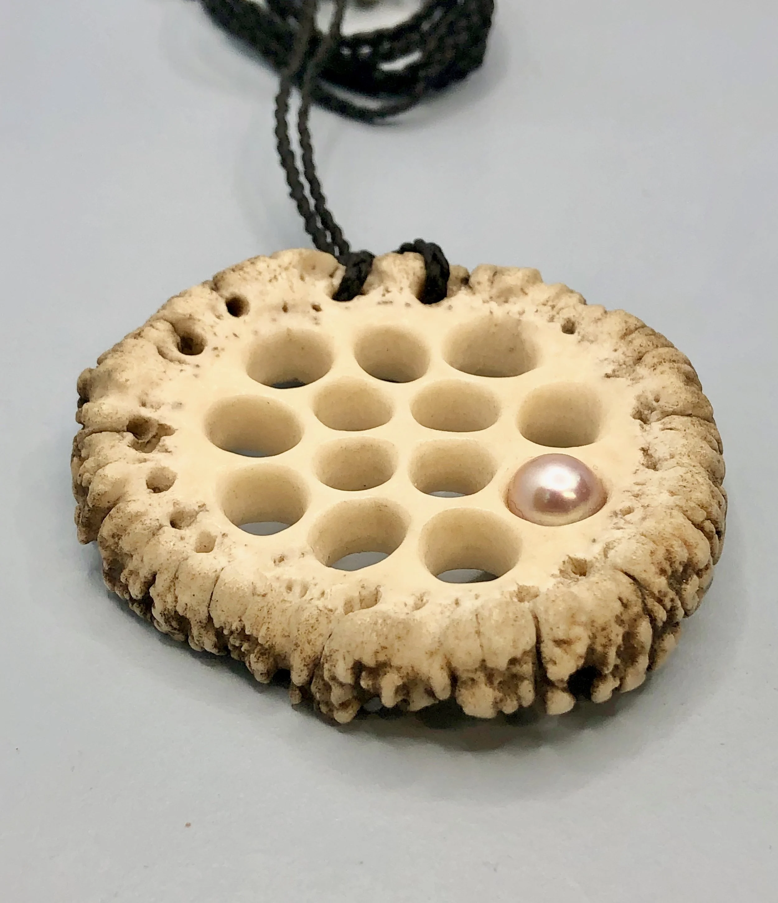 Hand carved antler inspired by lotus root shown from and angle to show the depth of the piece
