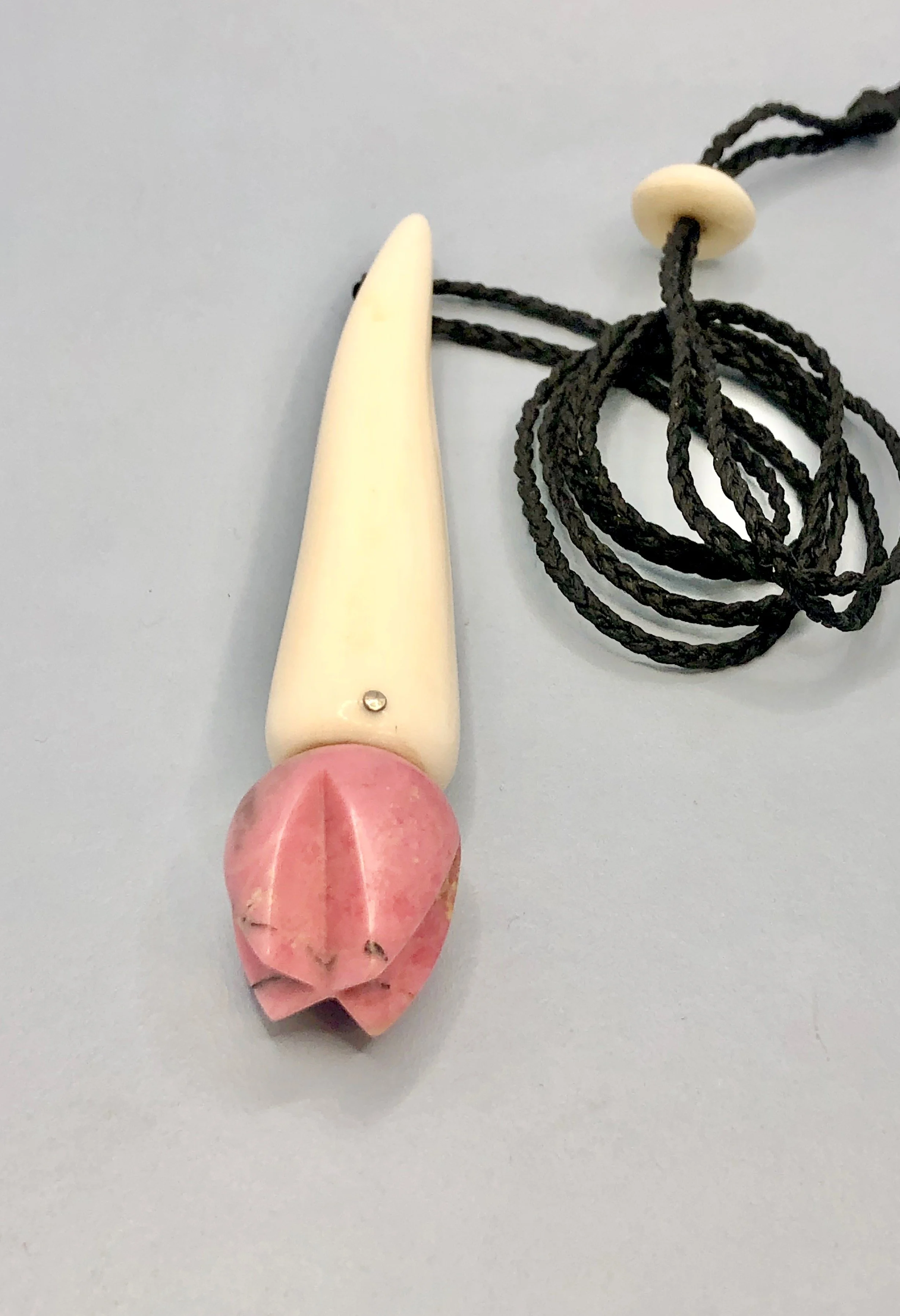 Angled front view of antler and pink rhodonite flower bud pendant