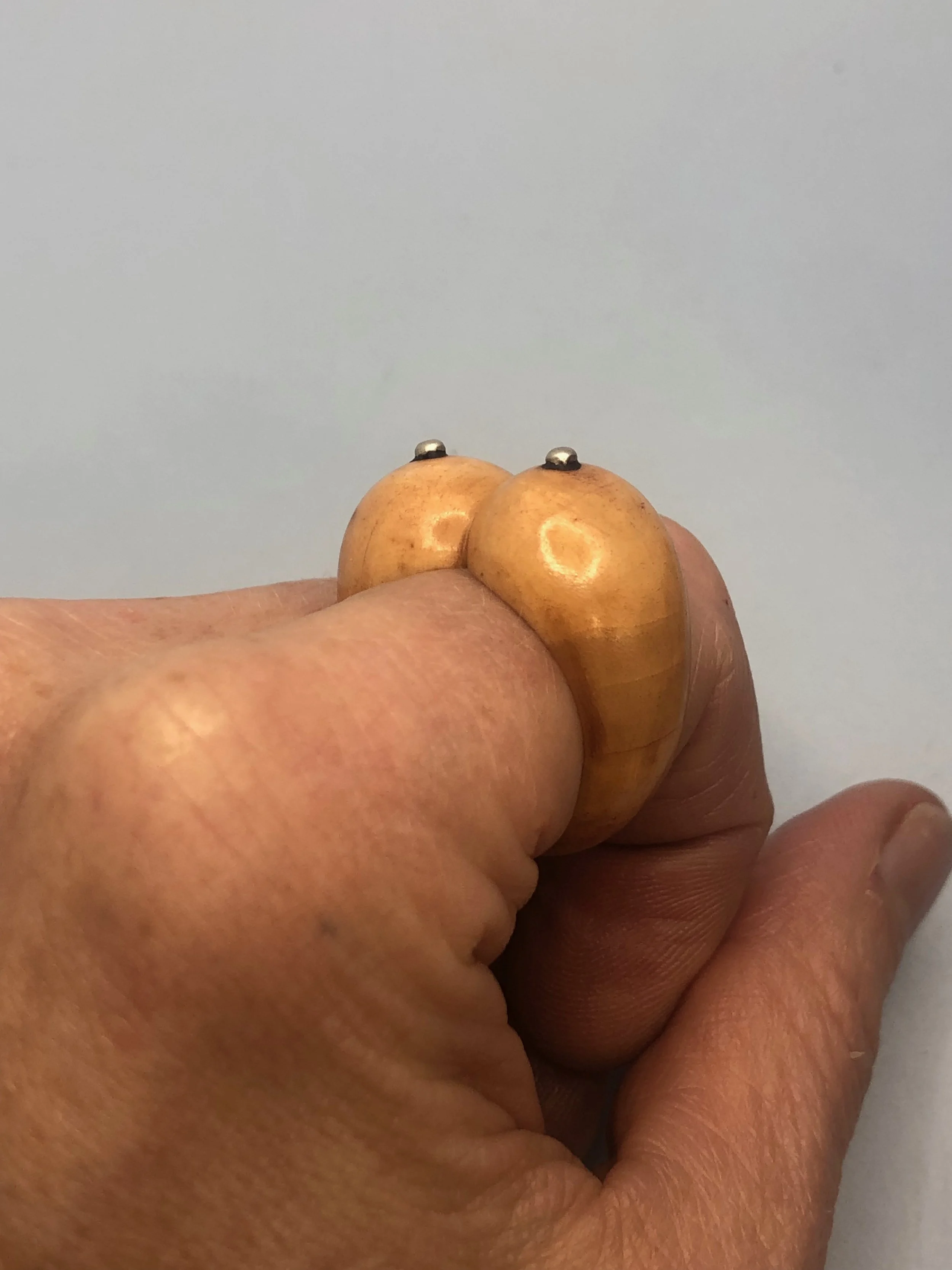 Hand carved bone boobs ring worn on finger showing height