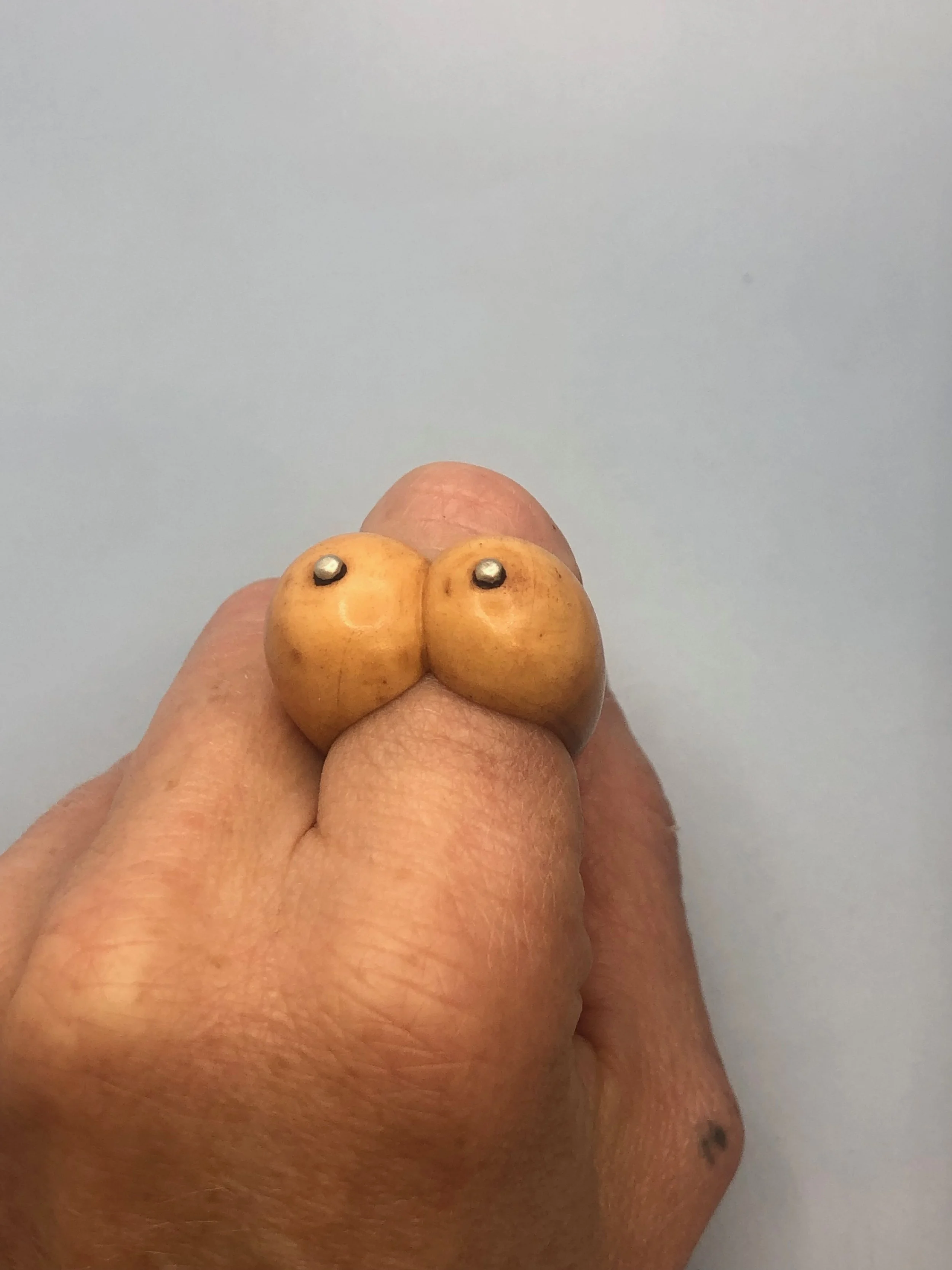Bone boobs ring worn on finger to show size and scale