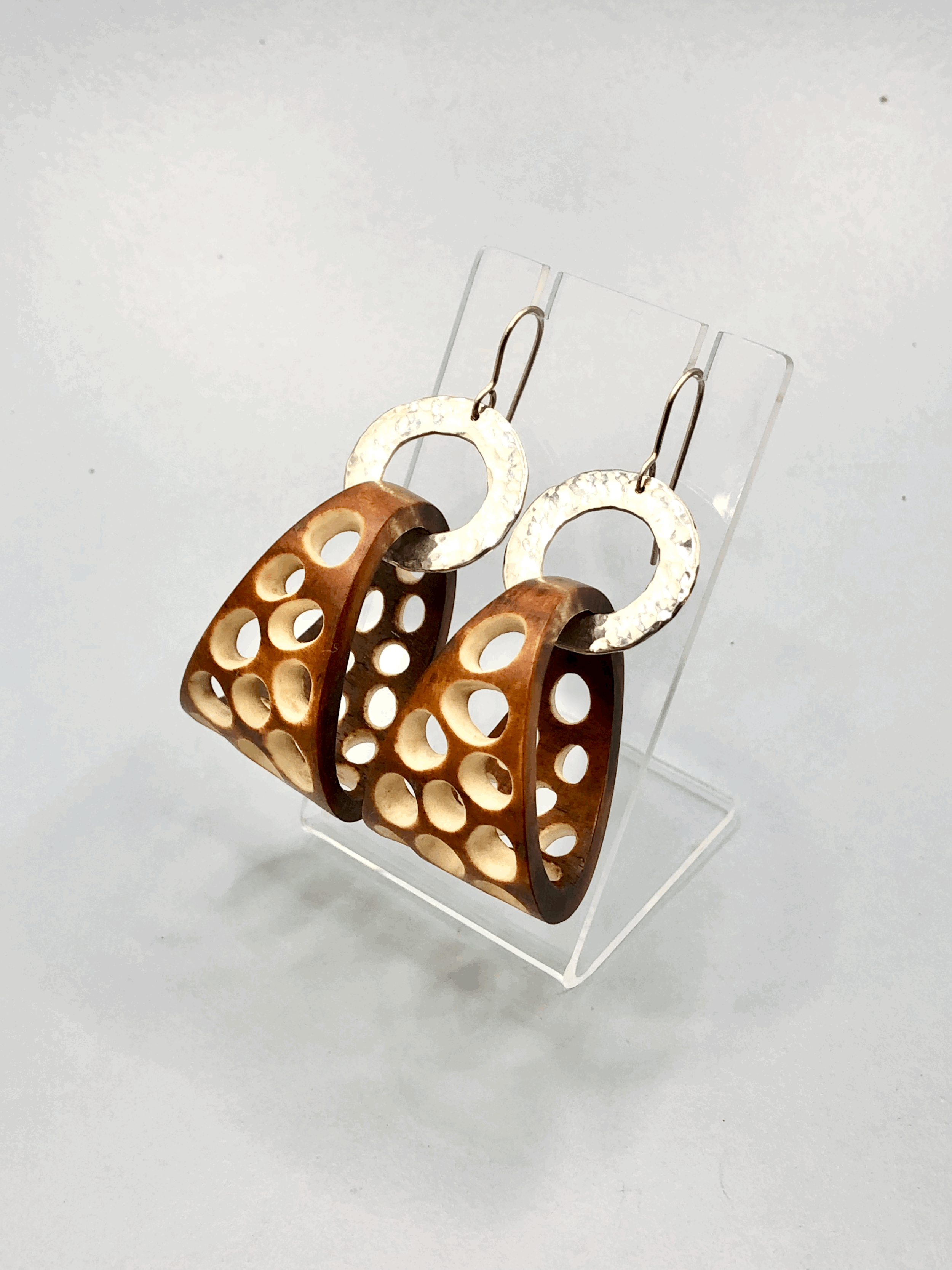 Close-up of carved antler basket hoop earring showing natural dye colour and texture